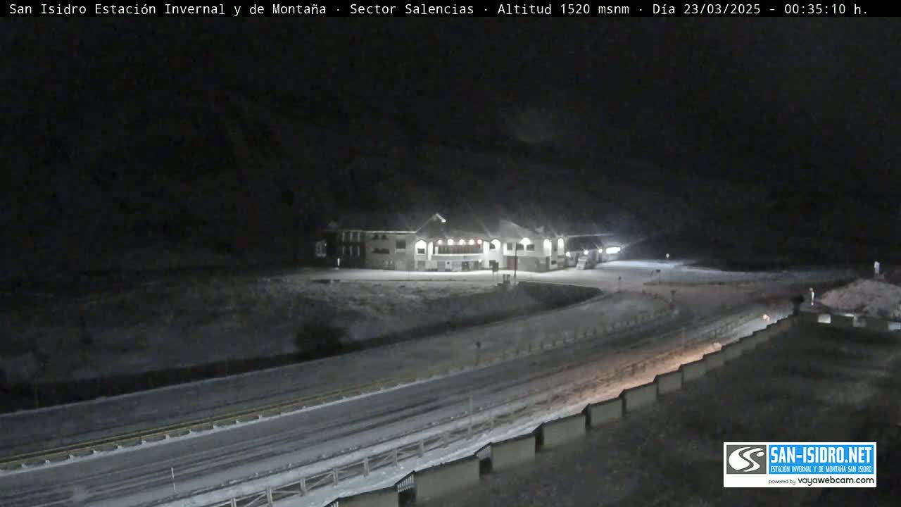 A snow-covered road and a lit building are visible at night.