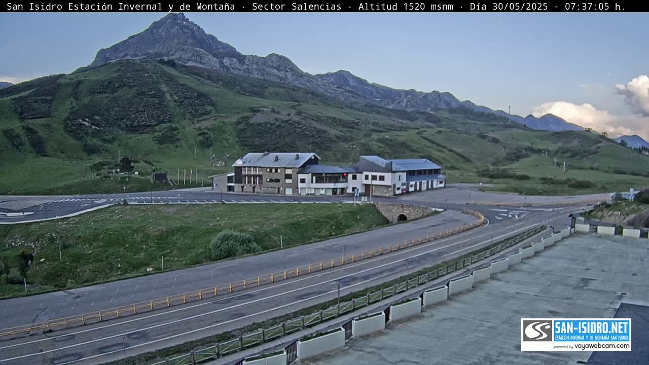 A mountainside resort with parking lots and roads under a mostly clear sky.