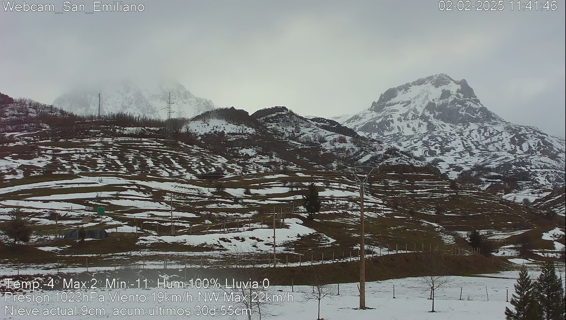 A snow-dusted mountainous landscape under an overcast sky.
