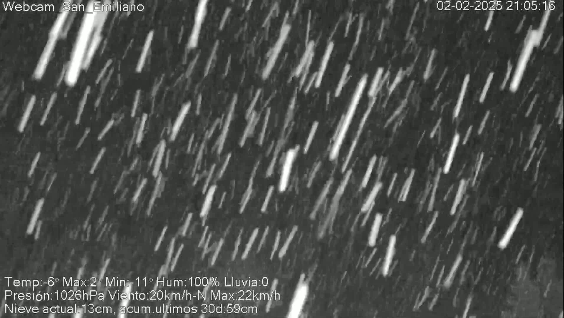 A nighttime outdoor scene shows heavy snowfall.