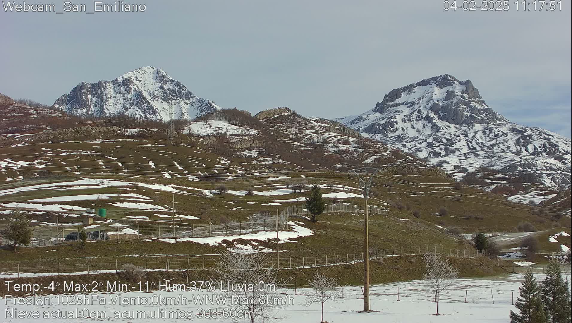 Snow-dusted hills and mountains are visible under a clear sky.