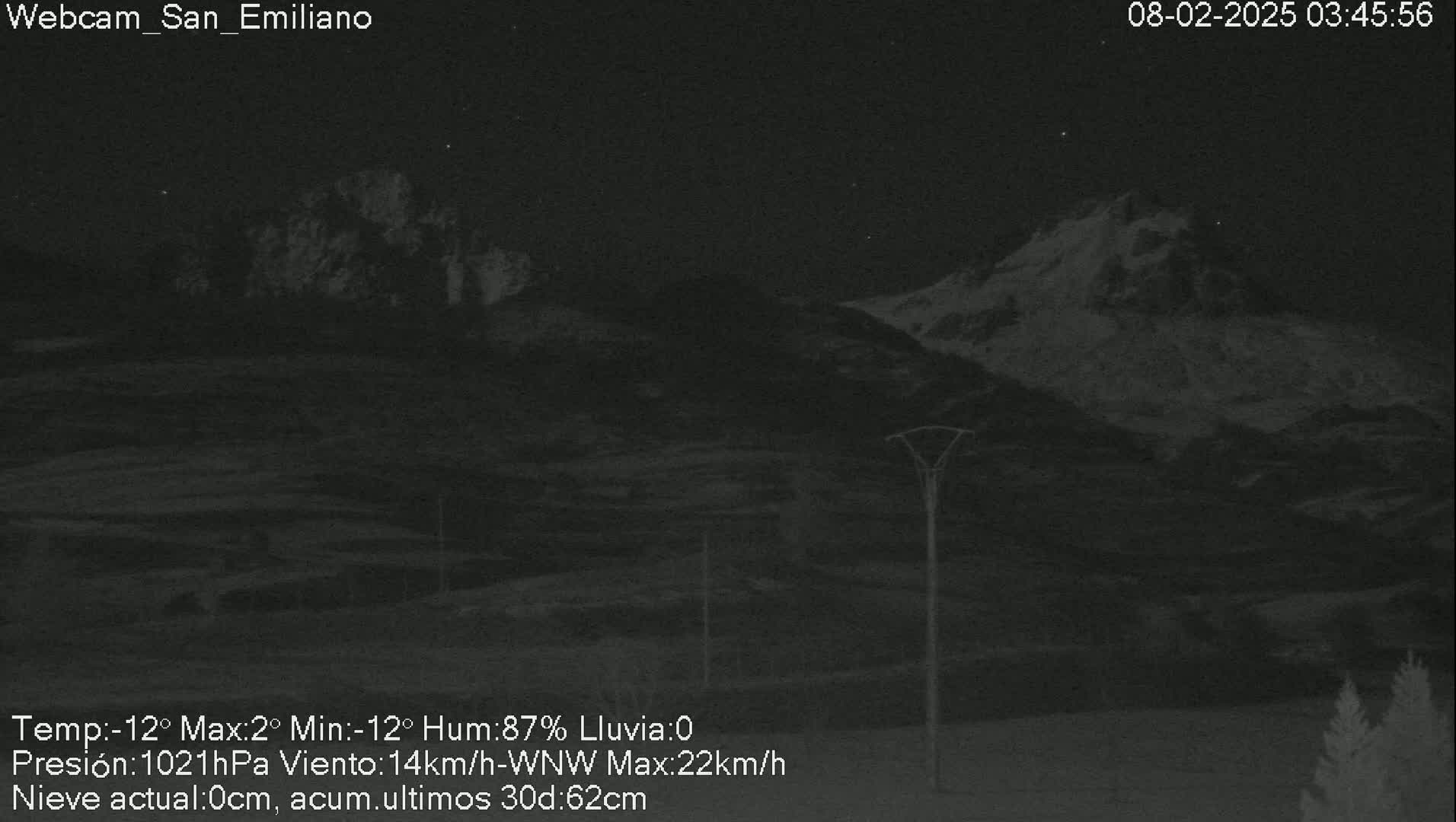 A nighttime view of snow-capped mountains under a clear sky.