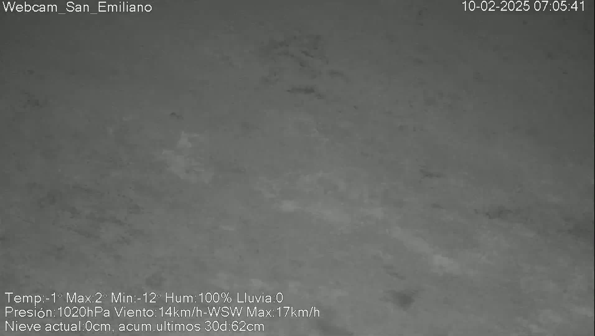 A low-resolution, gray-scale outdoor image shows overcast skies with snow accumulation on the ground.