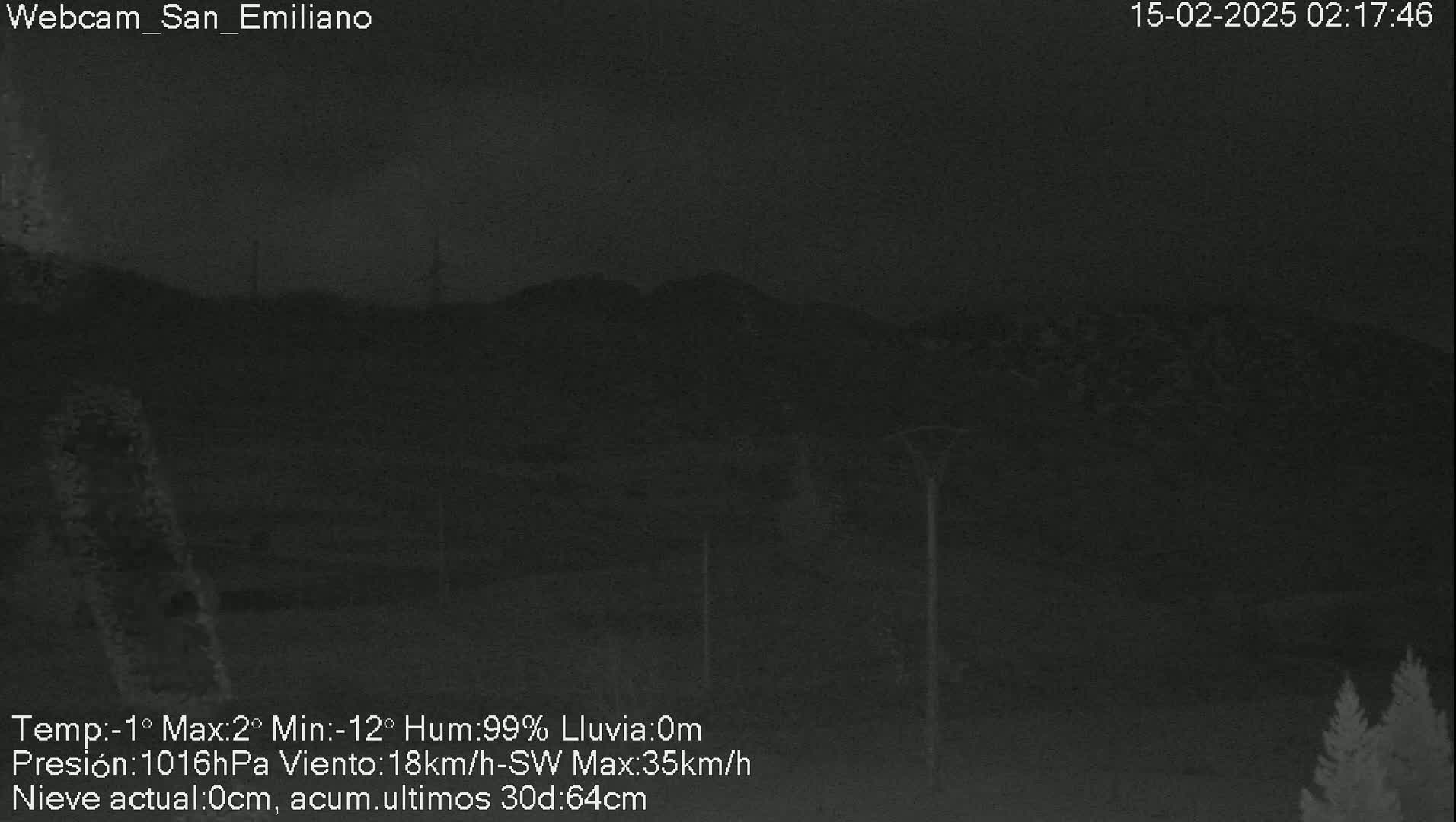 A nighttime, low-light view of dark hills and trees under a cloudy sky with 99% humidity and a southwest wind.