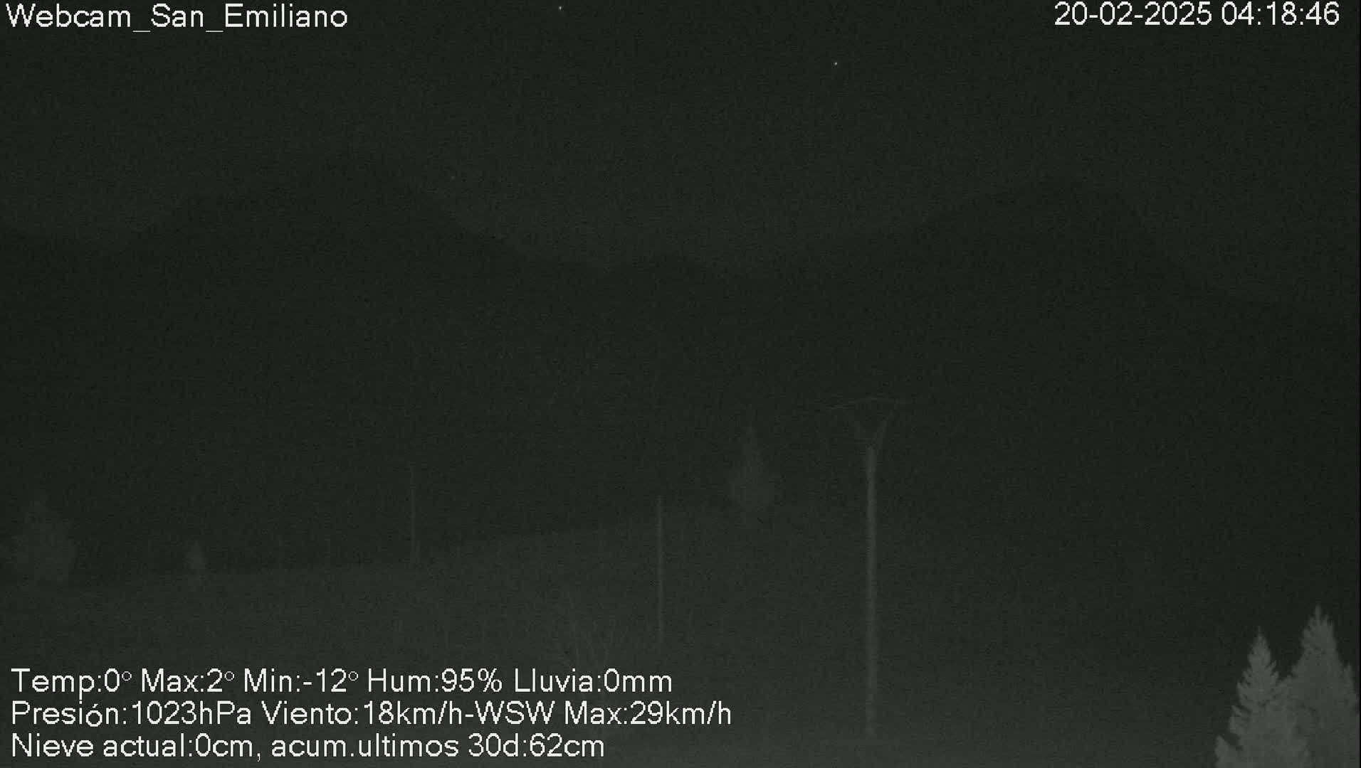 A nighttime, dark gray, low-visibility image shows a mountain range under a cloudy sky with a wind of 18 km/h from the west-southwest.