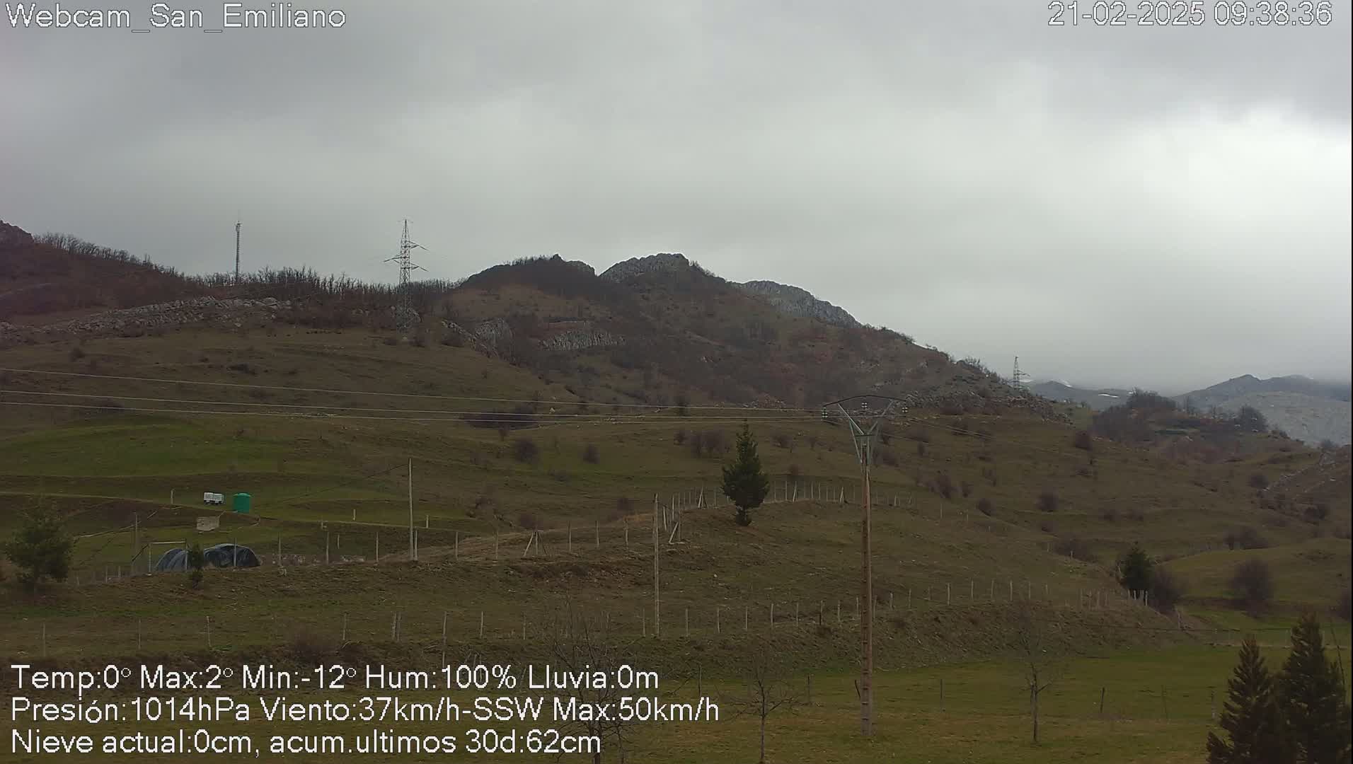 A view of a hilly, sparsely vegetated landscape under an overcast sky.