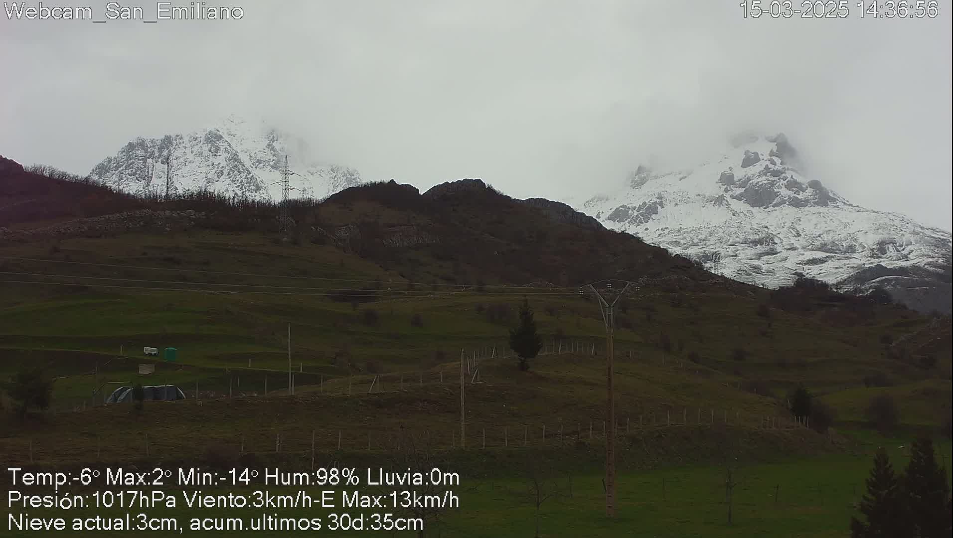 Snow-capped mountains are visible in the distance under an overcast sky.