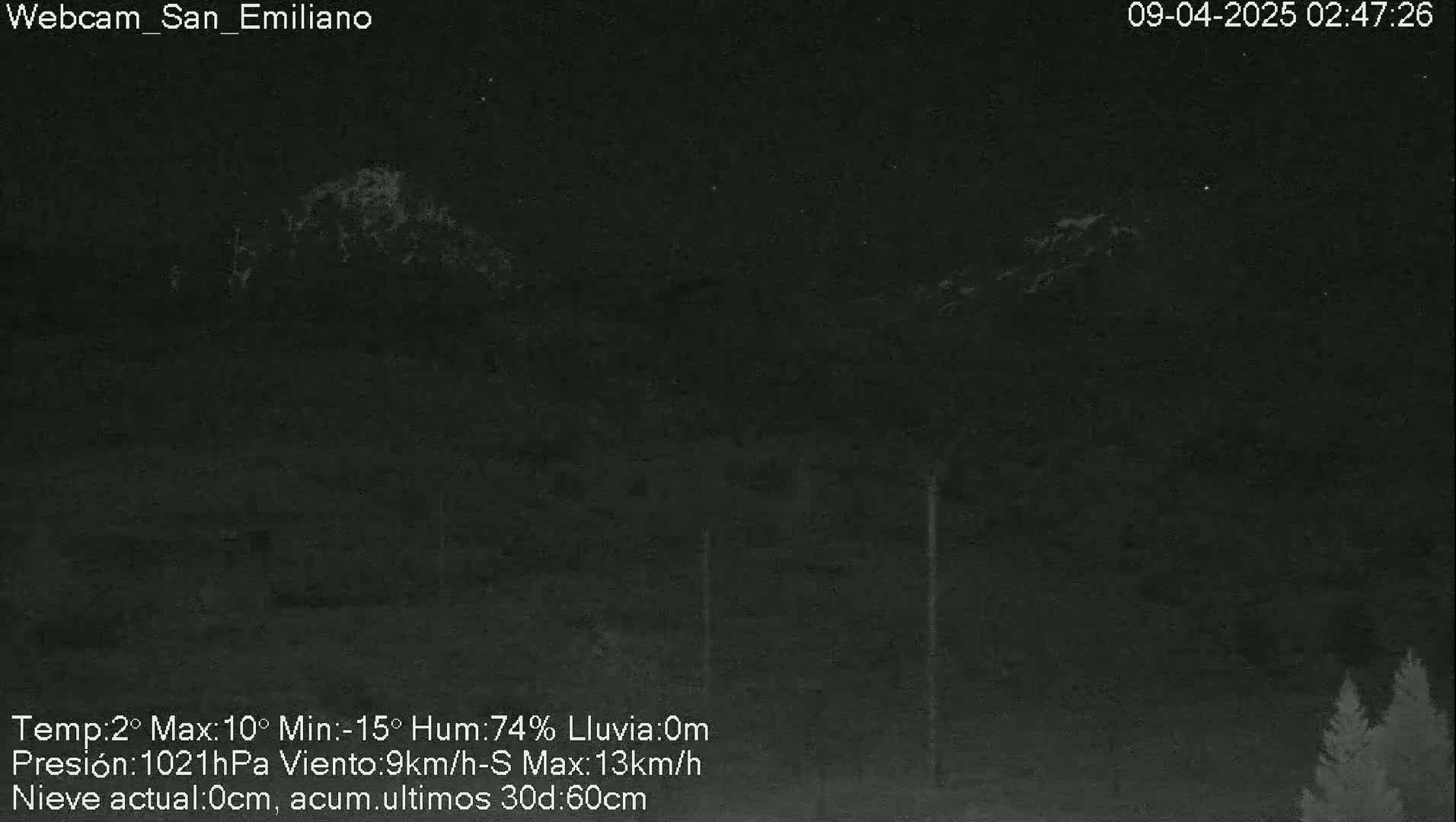 A nighttime, low-light view of a dark landscape with indistinct mountains in the background, under conditions of 74% humidity, no rain, and a 9 km/h south wind.