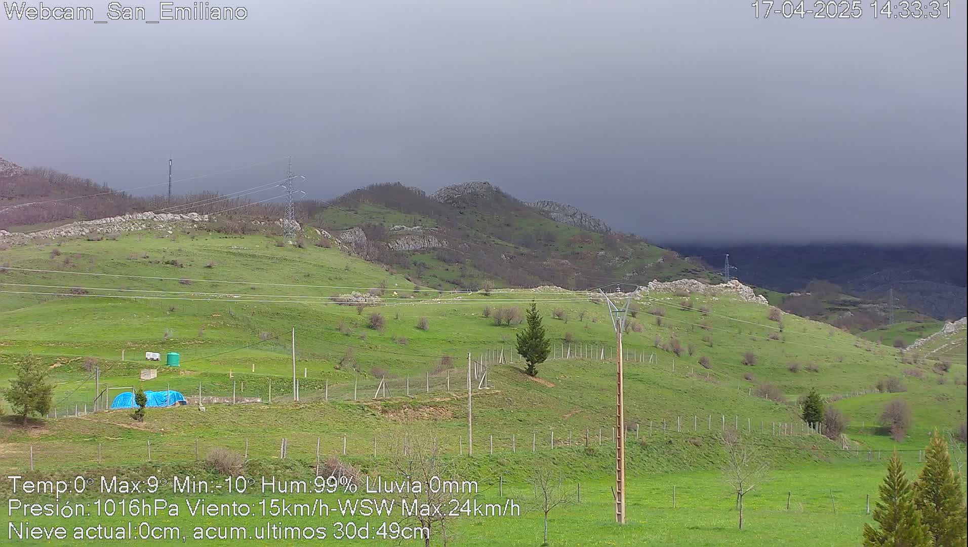 A sprawling green hillside under a heavily overcast sky.
