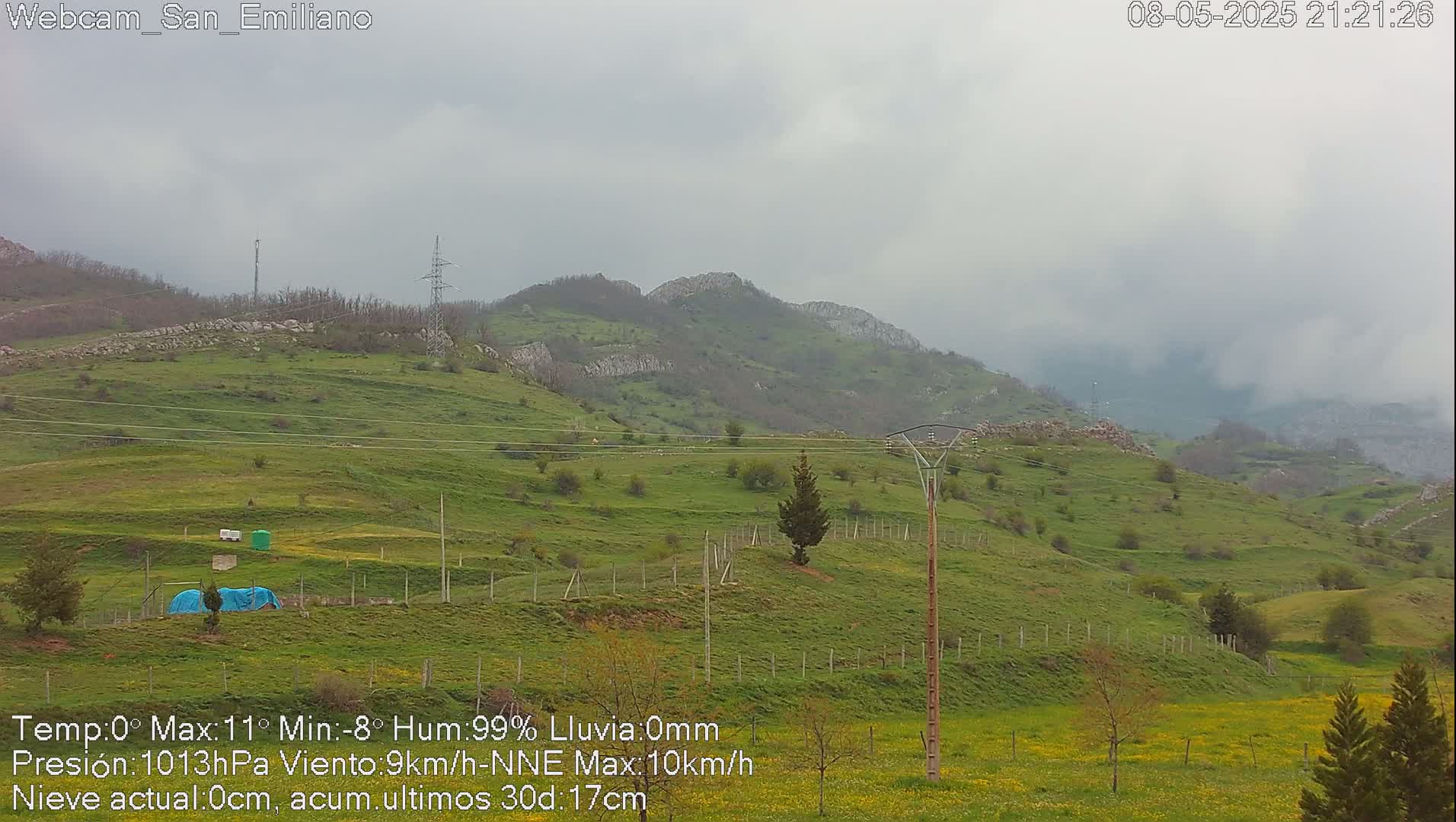 A view of rolling green hills under a cloudy sky.