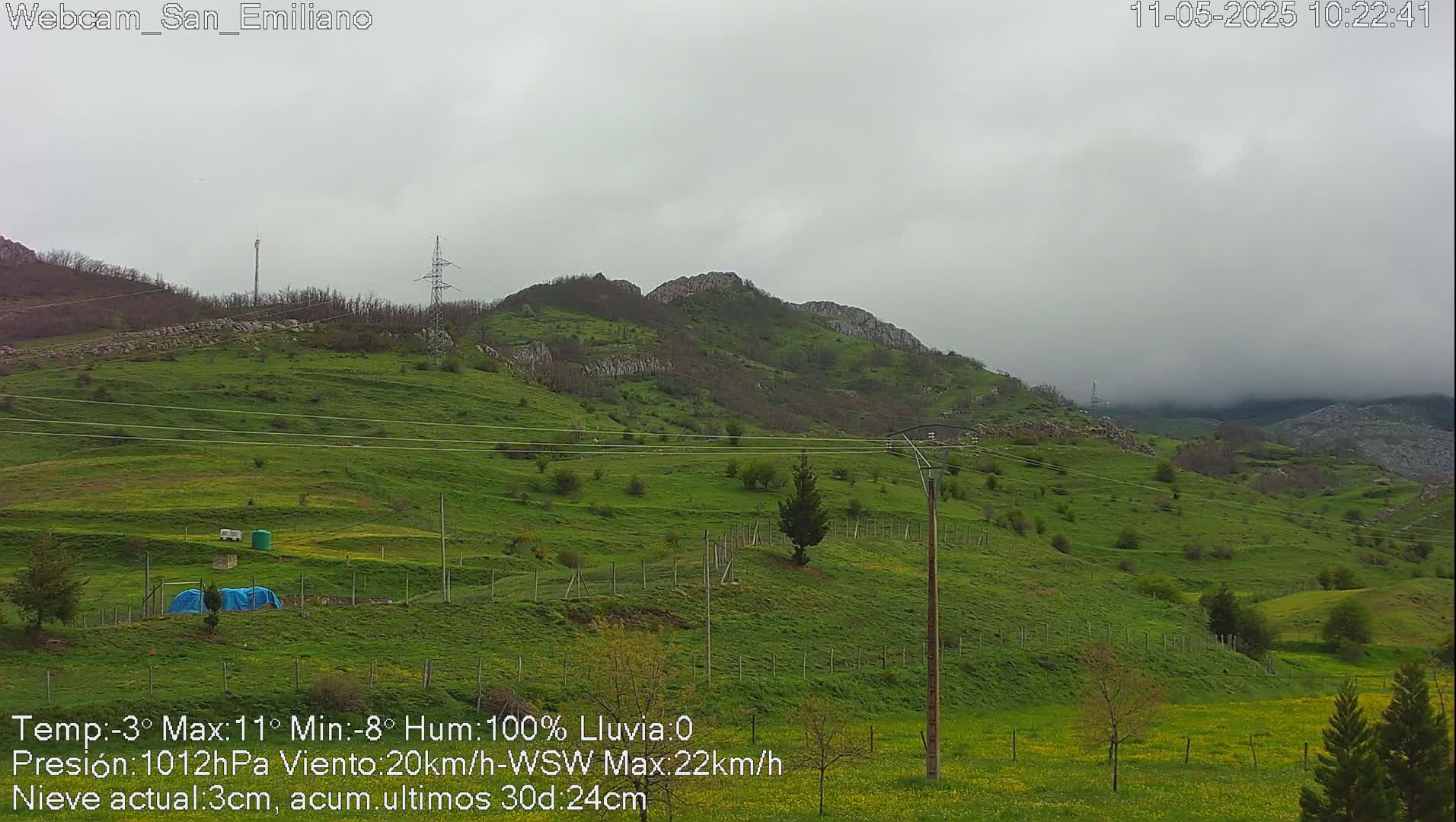 A green, hilly landscape under a cloudy, overcast sky.