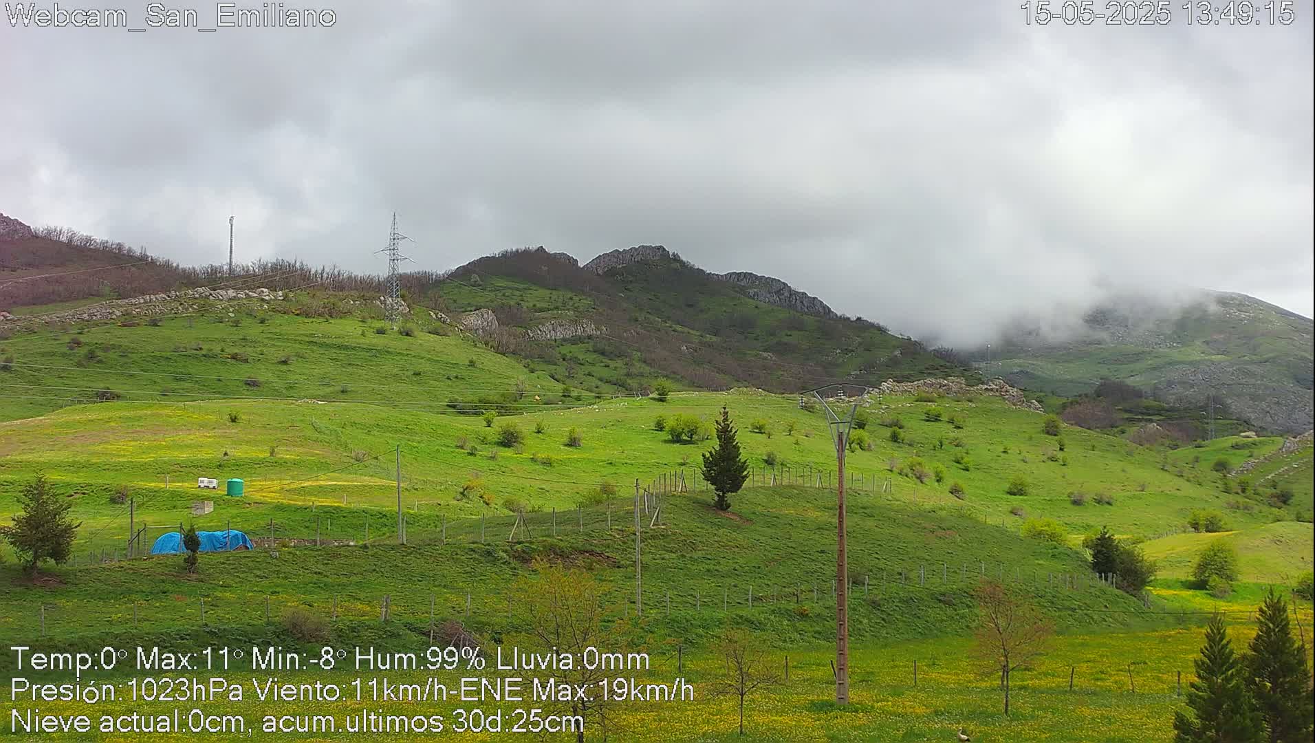 A green, hilly landscape under a cloudy, overcast sky.