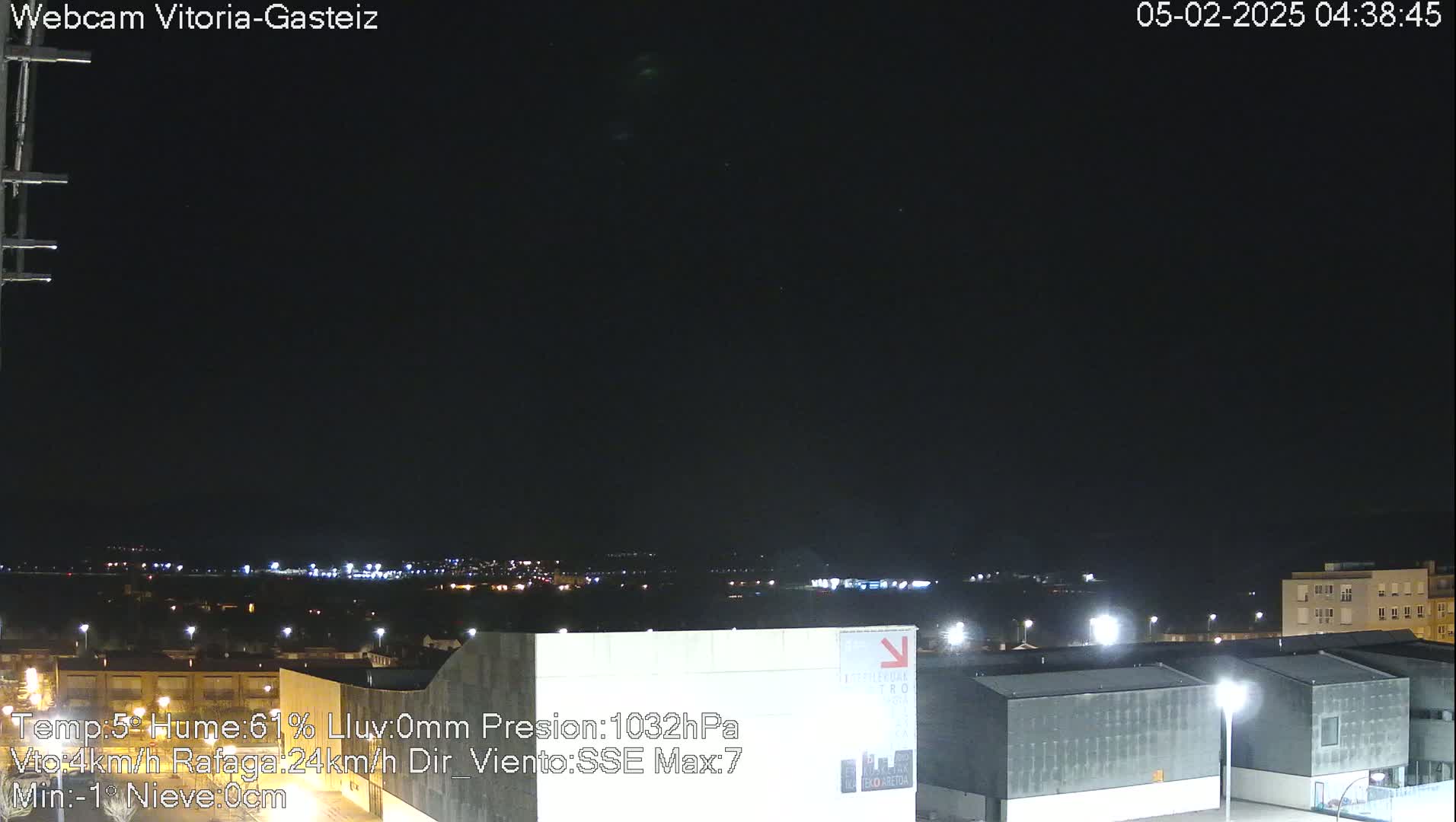 A nighttime view of a city illuminated by lights under a dark, clear sky.