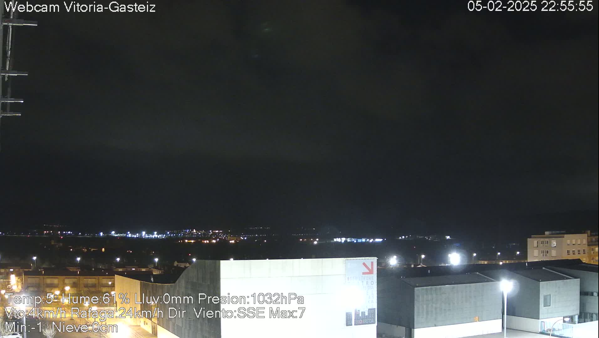 A nighttime long shot of a city under a dark, clear sky.