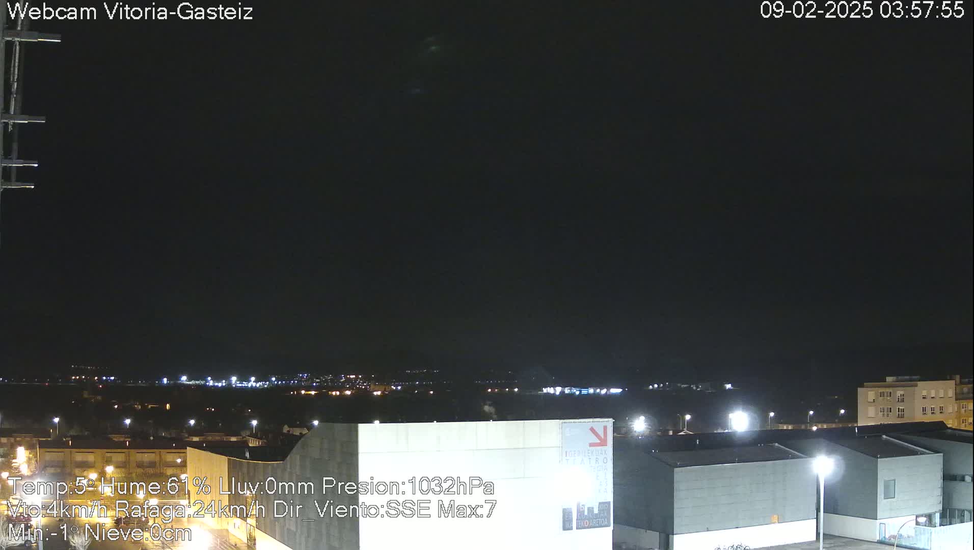 A nighttime view of a city illuminated by lights under a dark, clear sky.