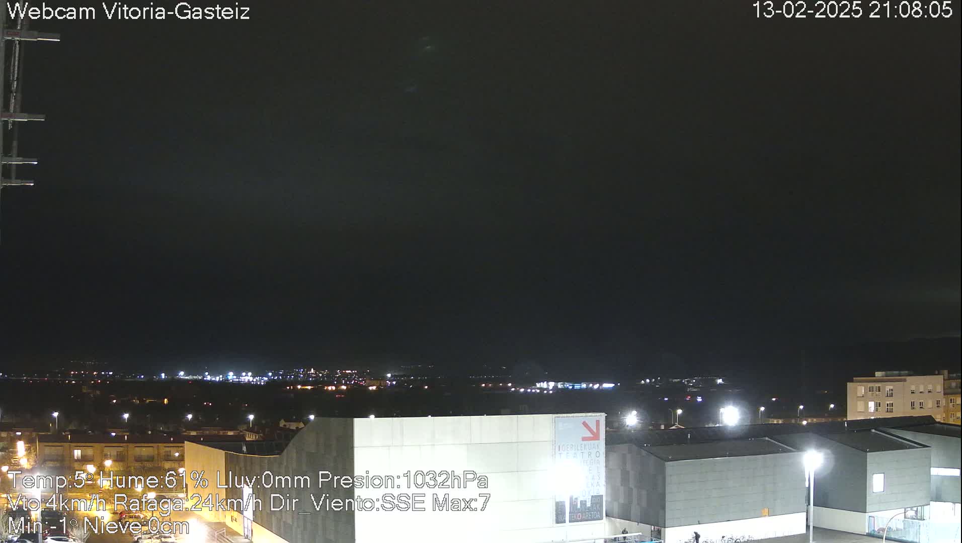 A nighttime view of a city illuminated by streetlights under a dark, mostly clear sky.