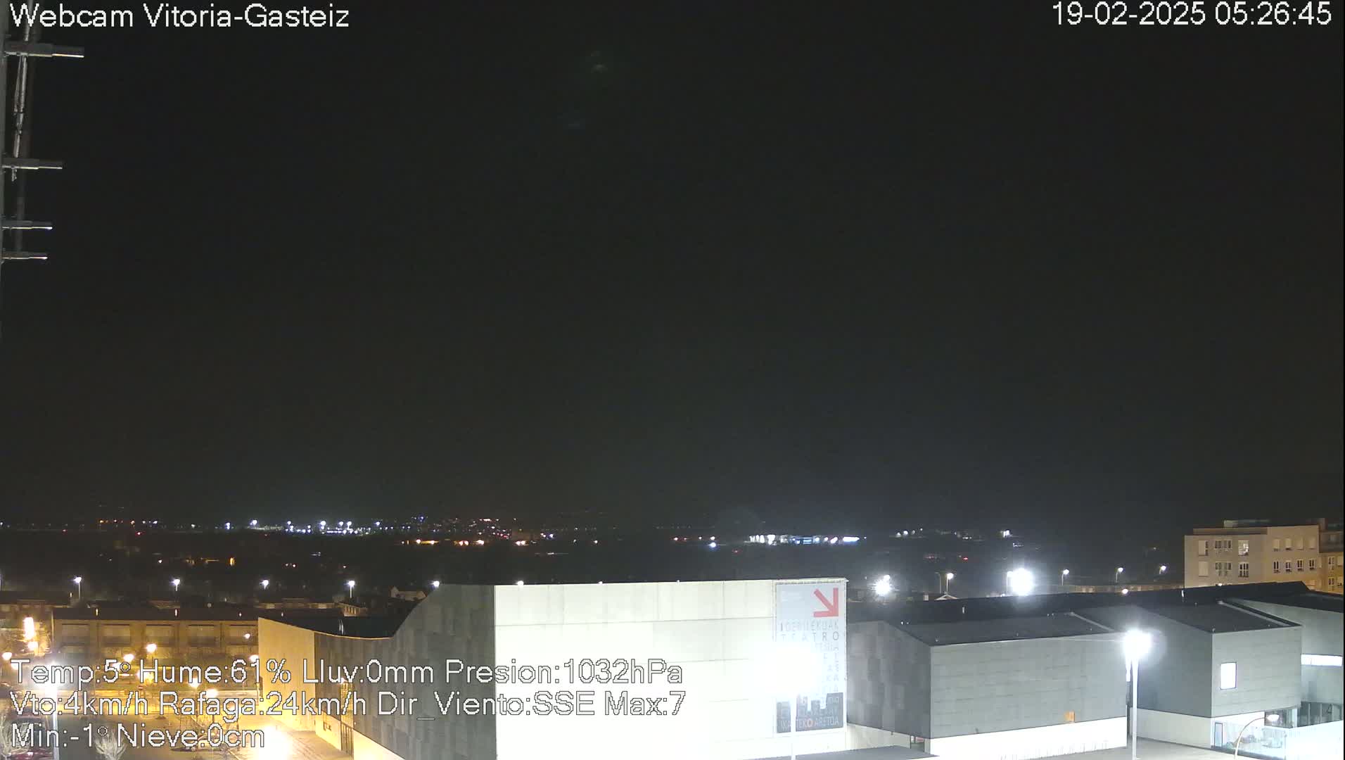A nighttime long shot of a city landscape under a dark, clear sky.