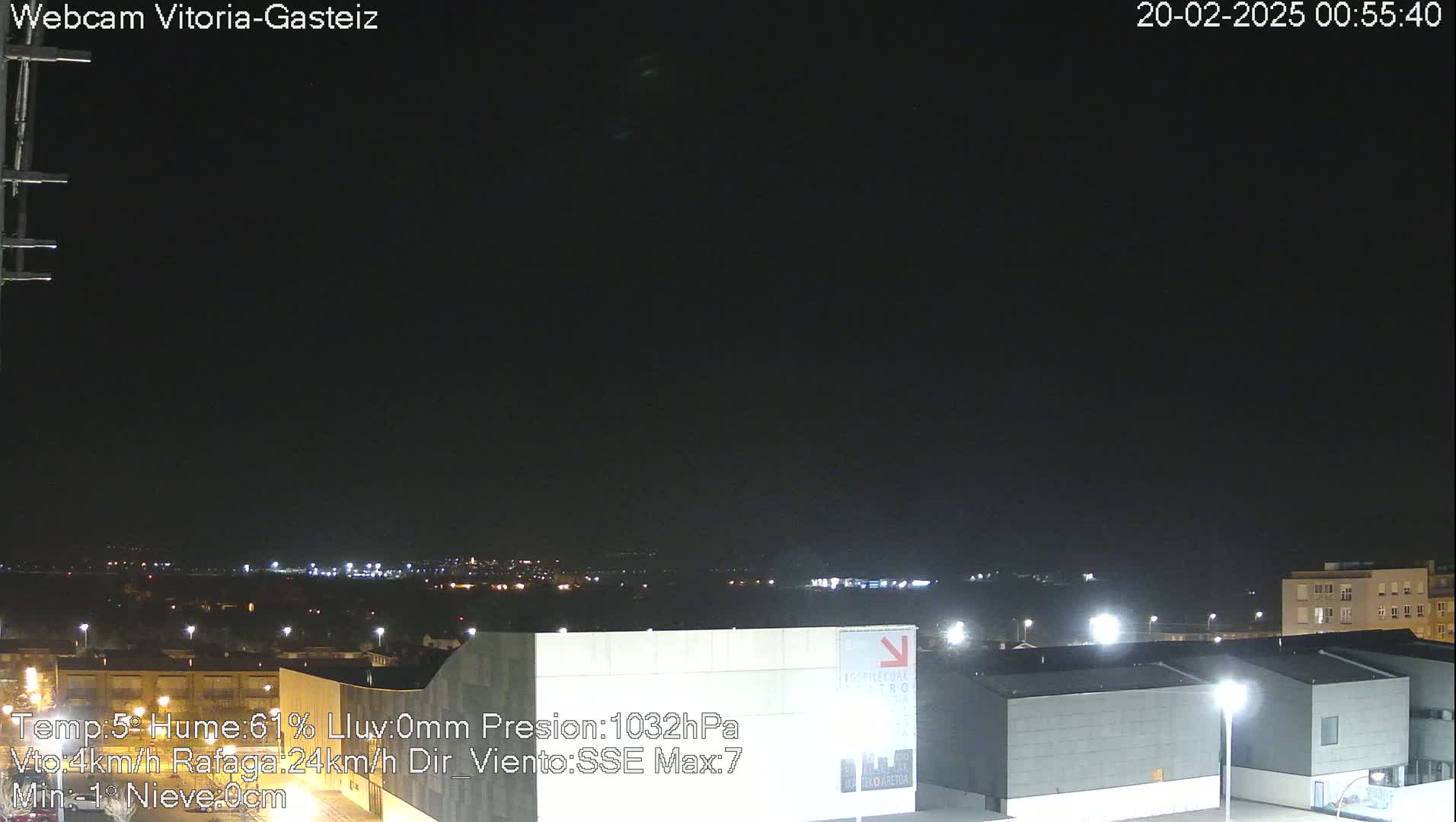 A nighttime view of a city skyline under a dark, clear sky.