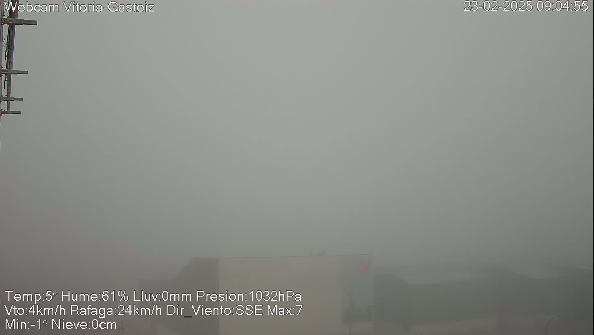 A thick fog obscures the view of a building in the distance.