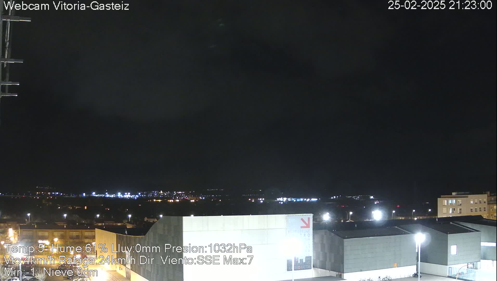 A nighttime view of a city illuminated by streetlights under a dark, clear sky.