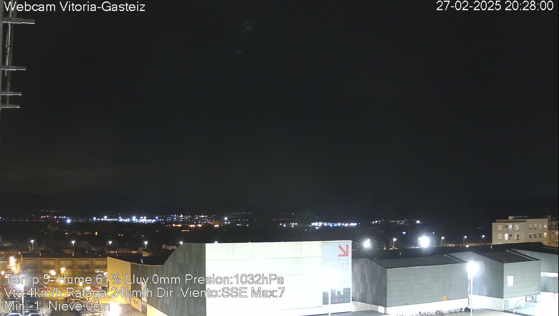 A nighttime view of a city skyline under a dark, clear sky.
