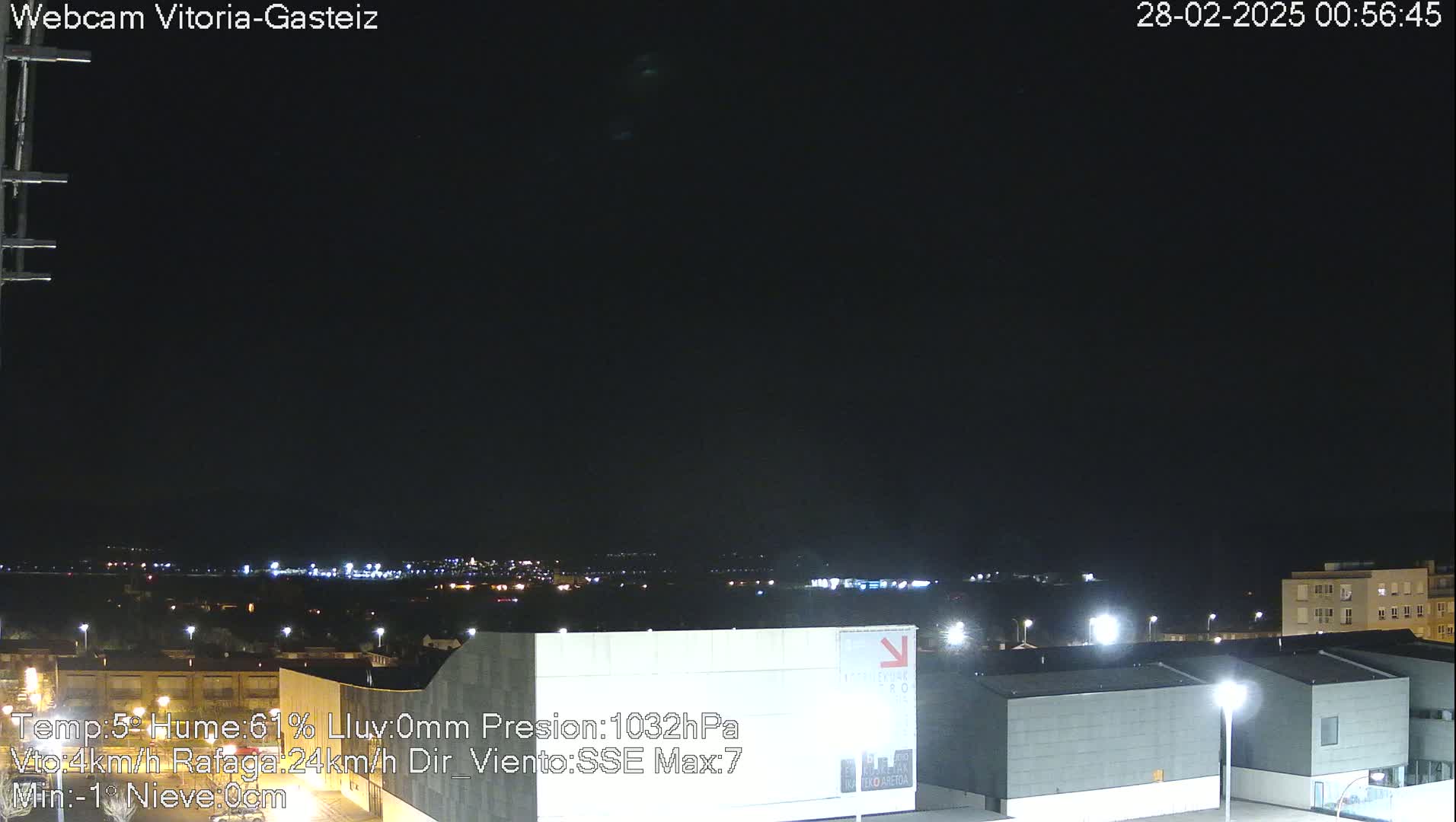 A nighttime long shot of a city skyline under a clear, dark sky.
