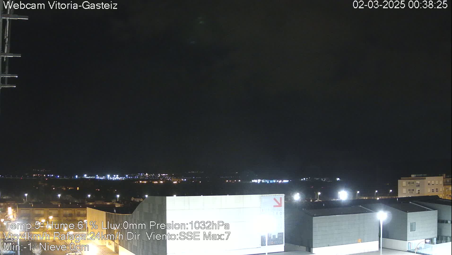 A nighttime view of a city skyline under a dark, clear sky.
