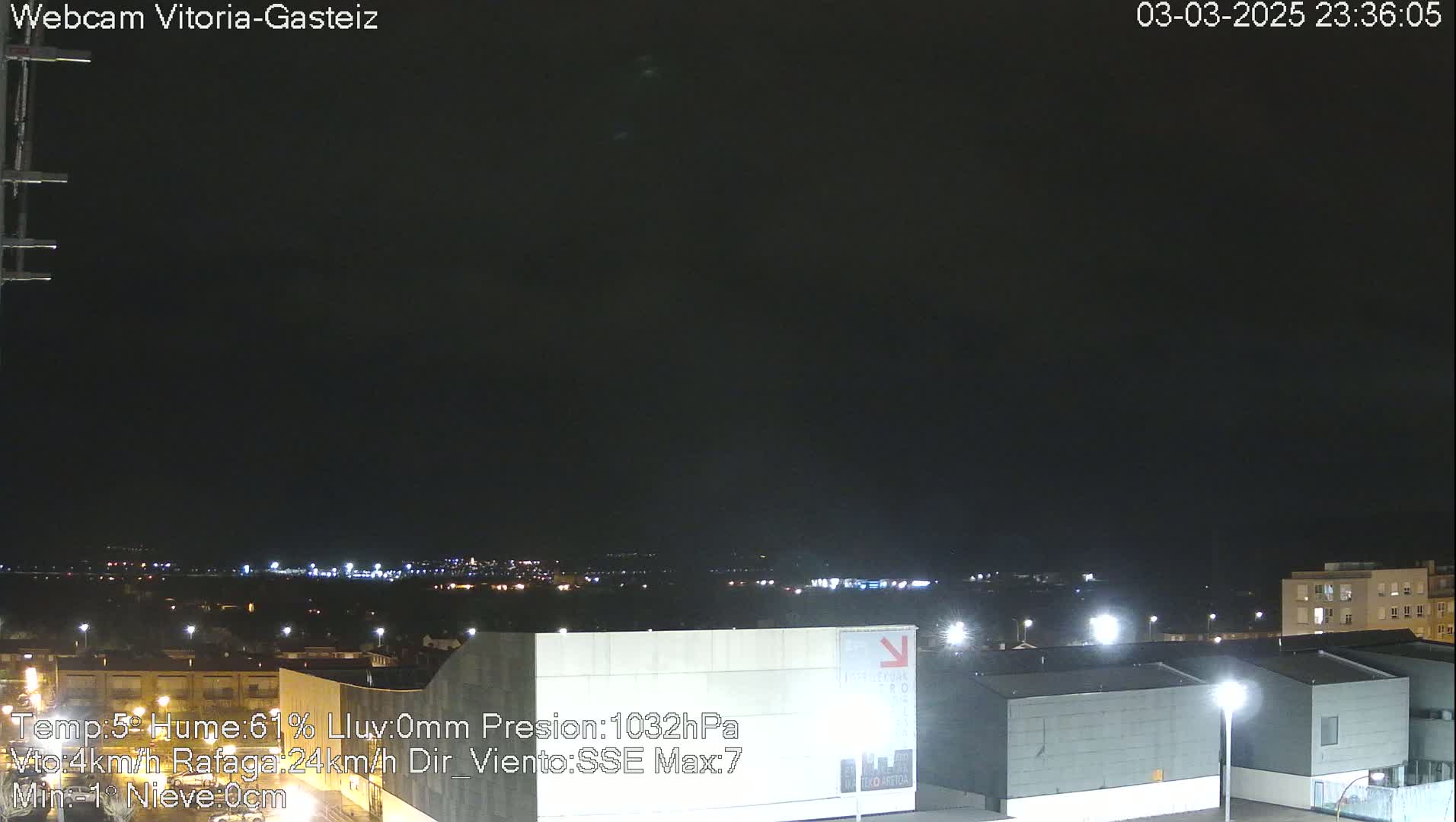 A nighttime view of a city illuminated by lights under a dark, clear sky.