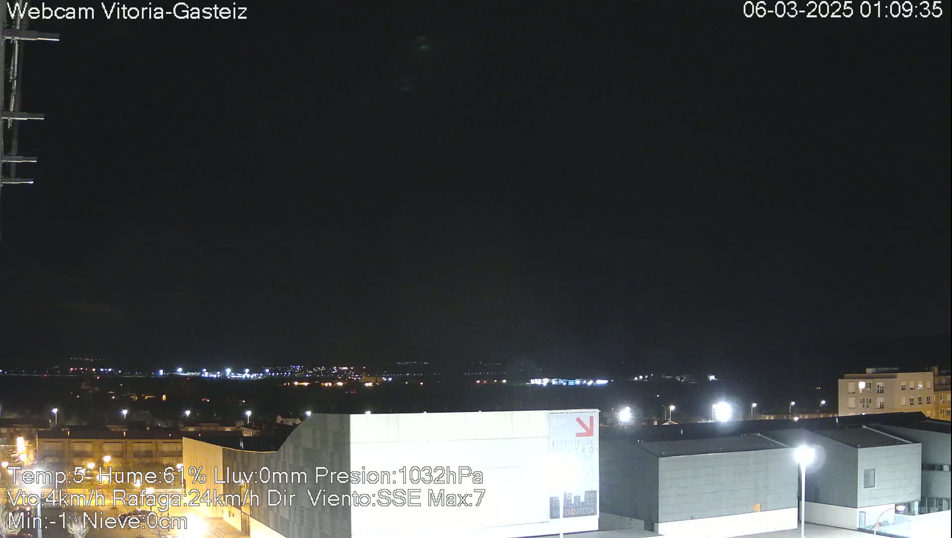 A nighttime view of a city illuminated by lights, under a dark, clear sky.