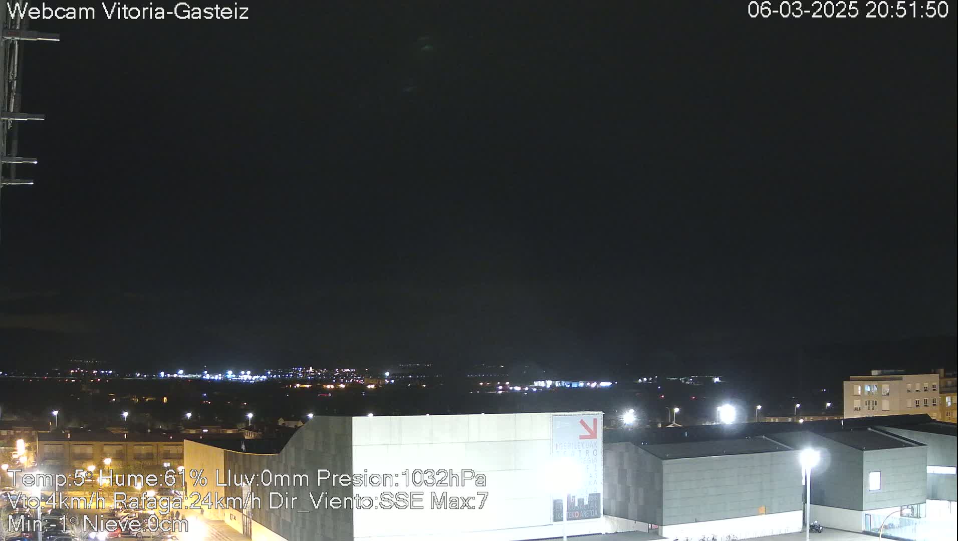 A nighttime view of a city illuminated by lights under a clear, dark sky.