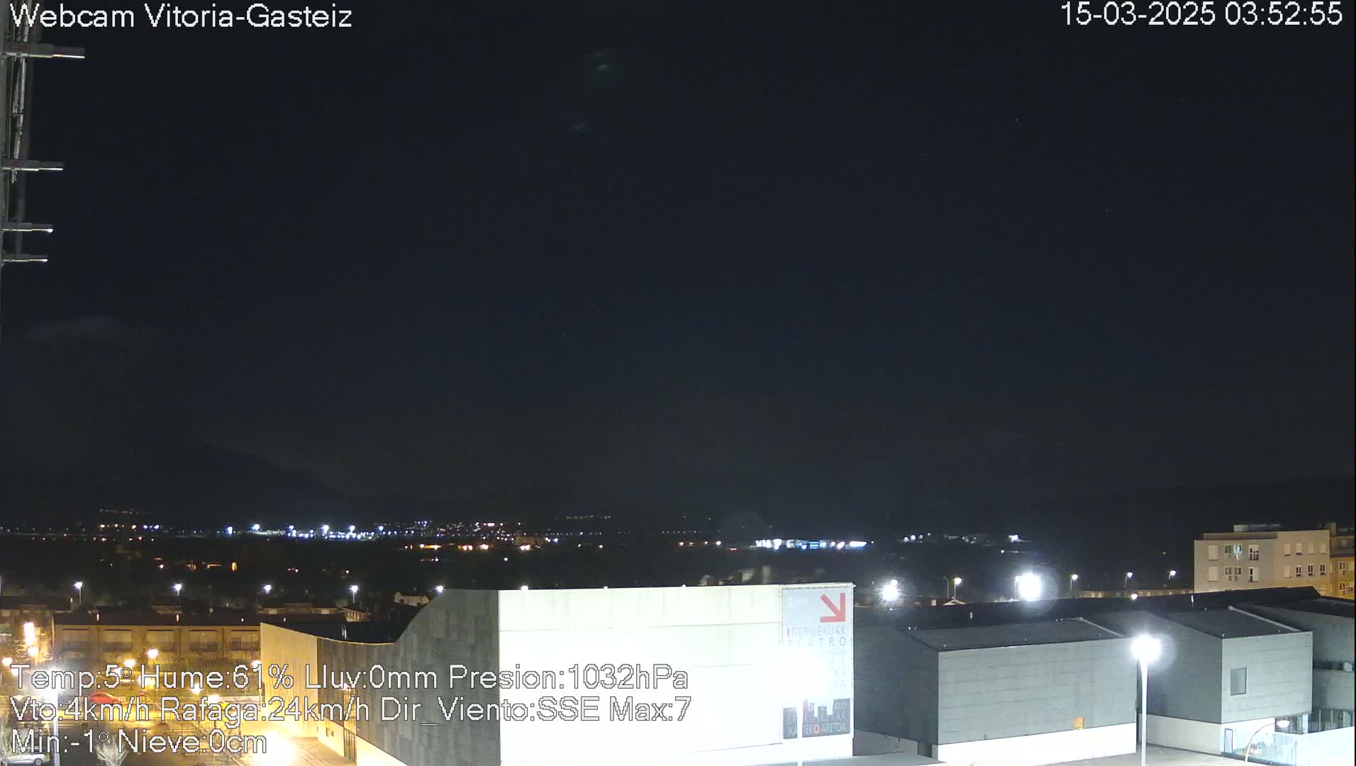 A nighttime long shot of a city under a dark, clear sky.
