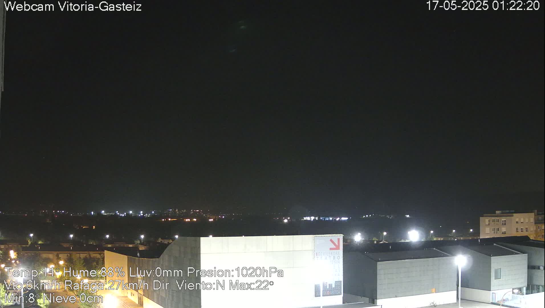 A nighttime view of a city skyline under a clear, dark sky.