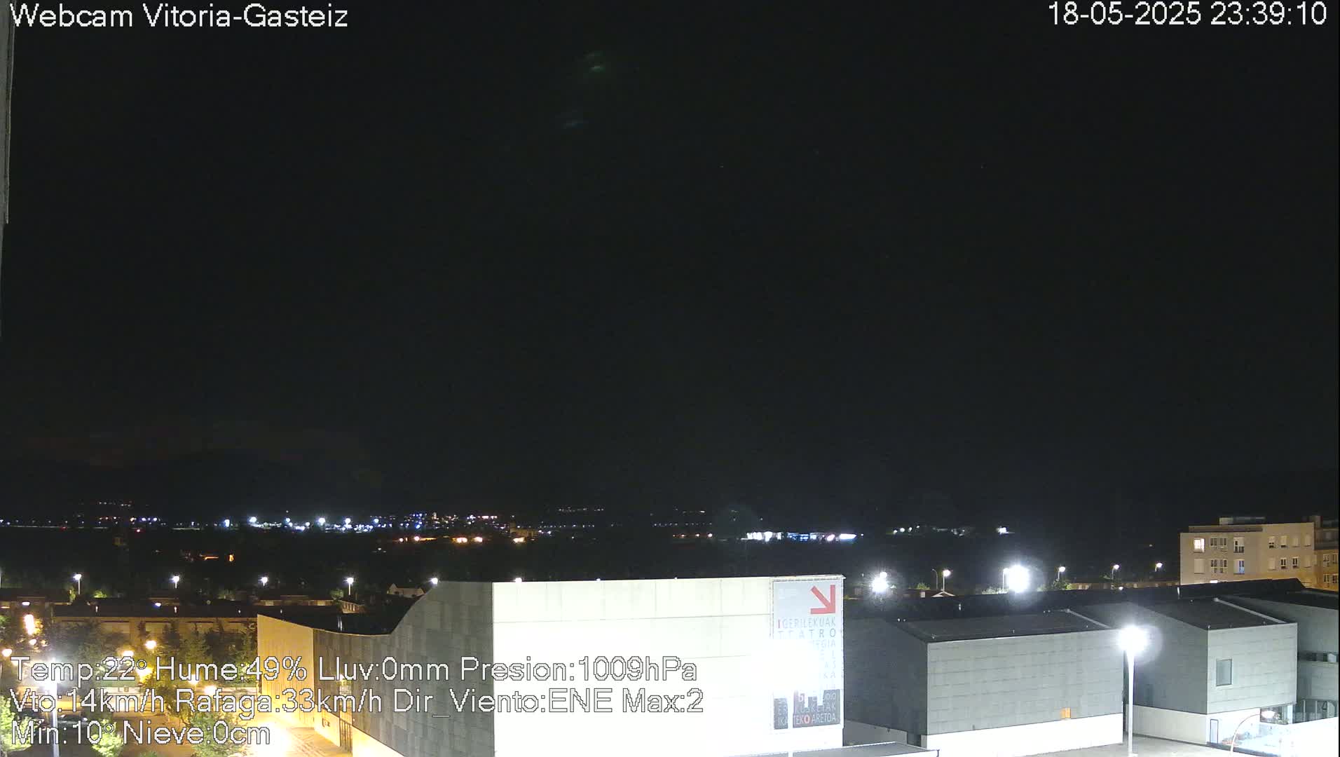 A nighttime view of a city illuminated by lights under a dark, clear sky.