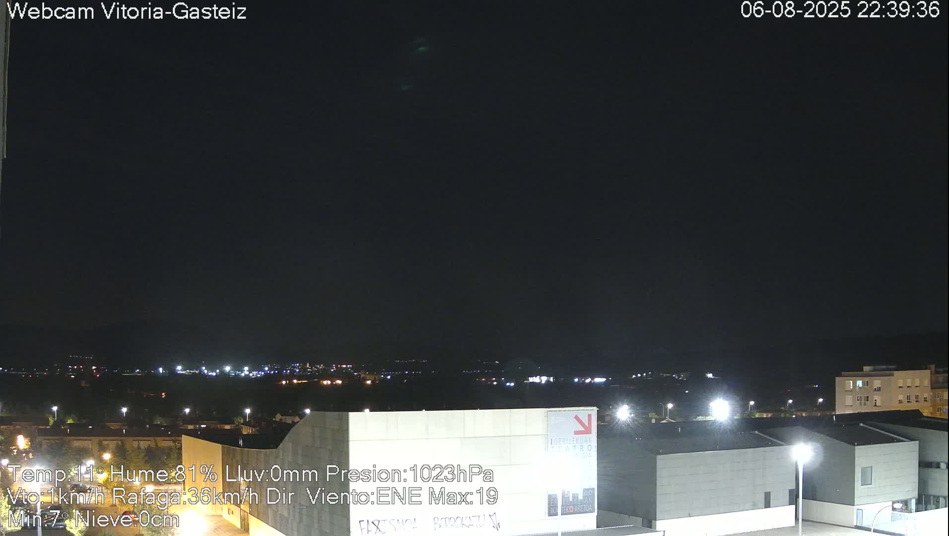 A nighttime view of a city illuminated by lights under a dark, clear sky.