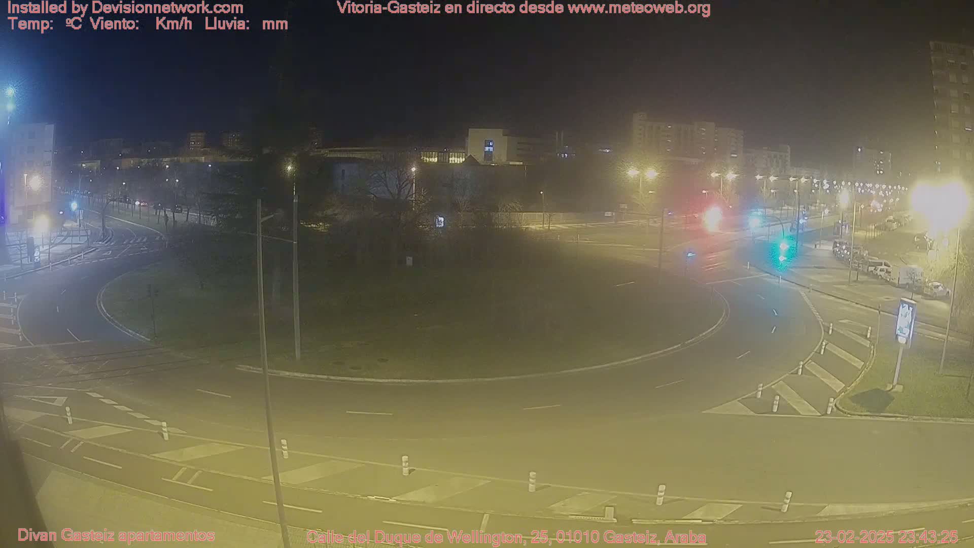 A nighttime view of a roundabout with cars and streetlights, under a clear, dark sky.