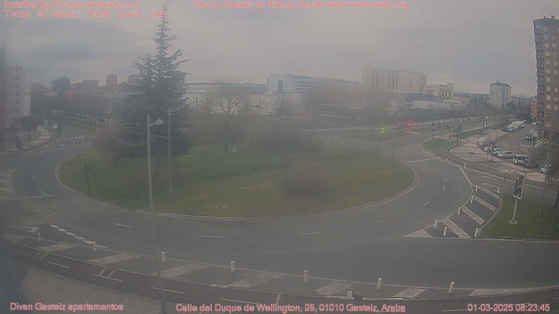 A hazy view of a roundabout and surrounding urban area on an overcast day.