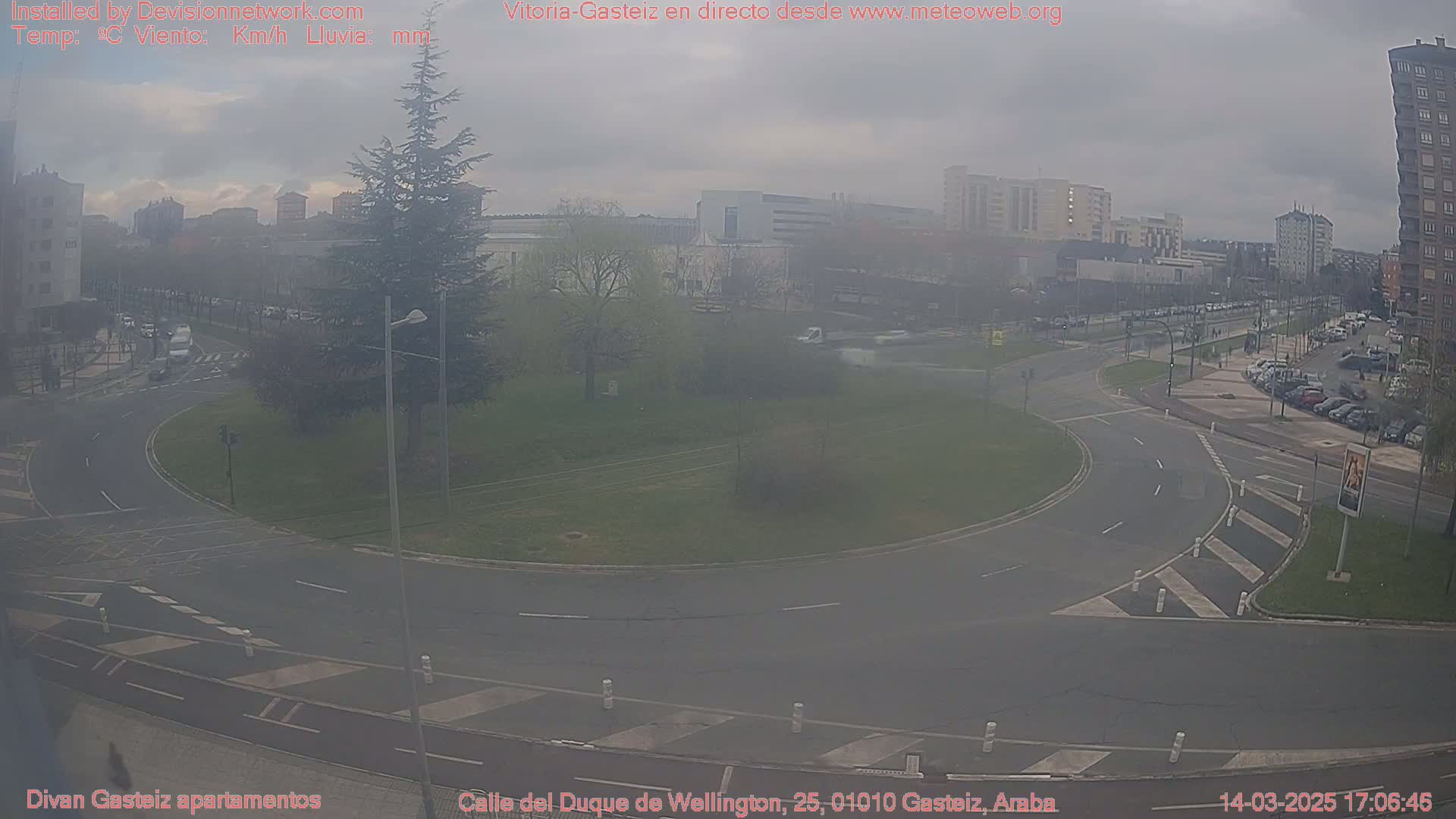 A hazy view of a roundabout and city streets with overcast skies.