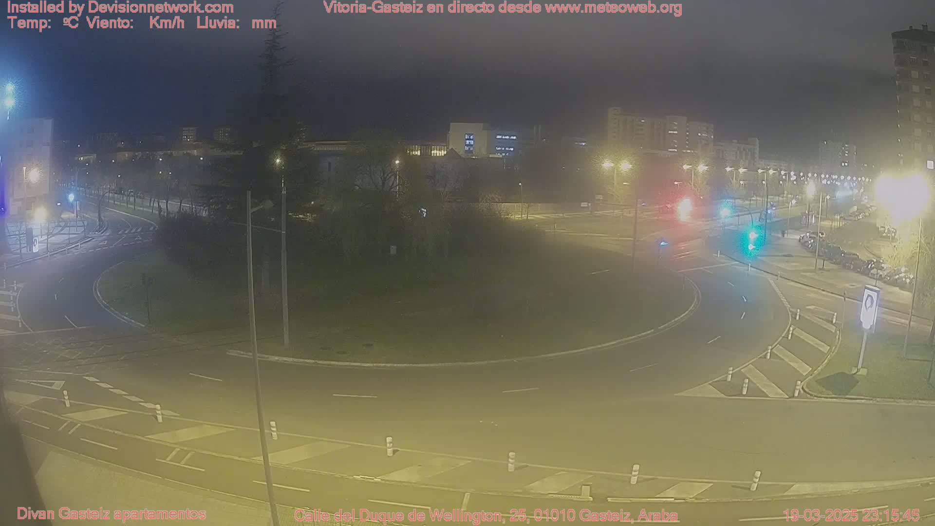 A nighttime view of a roundabout and surrounding streets, illuminated by streetlights.