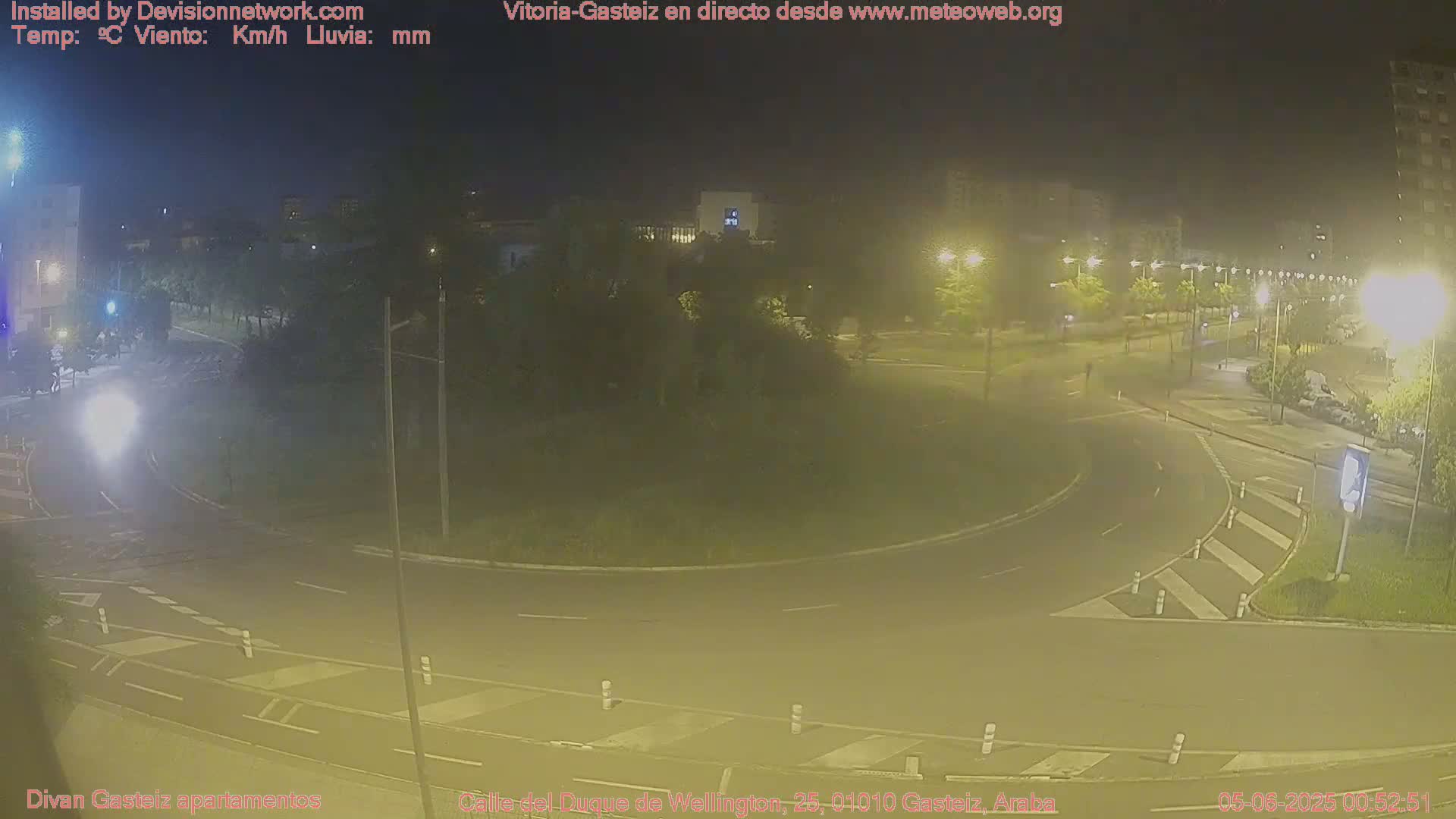 A nighttime view of a roundabout and surrounding streets, illuminated by streetlights.