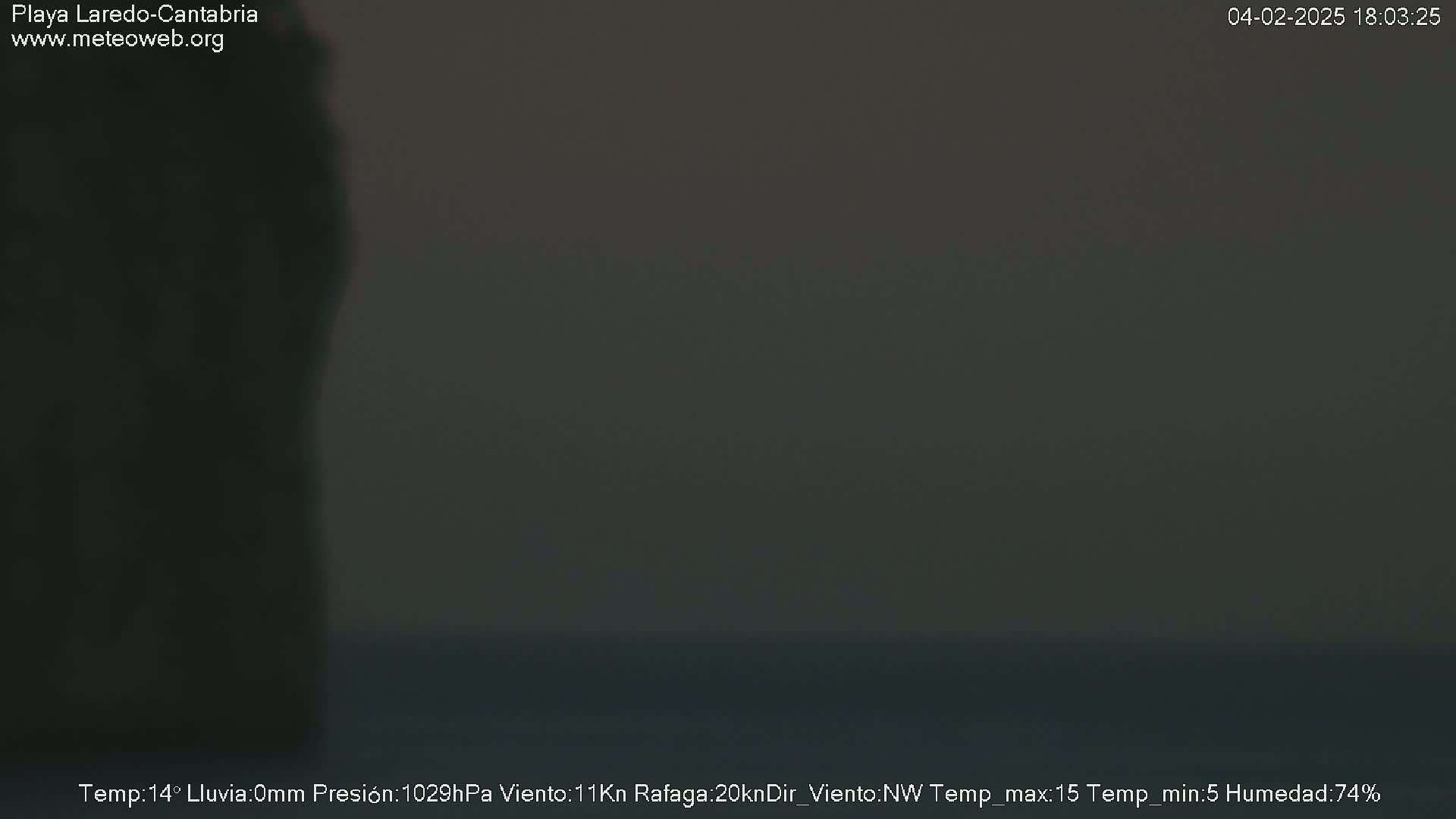 A dark, blurry image shows a mostly dark-colored scene with a hint of a lighter area at the bottom, possibly depicting an overcast or nighttime outdoor setting.