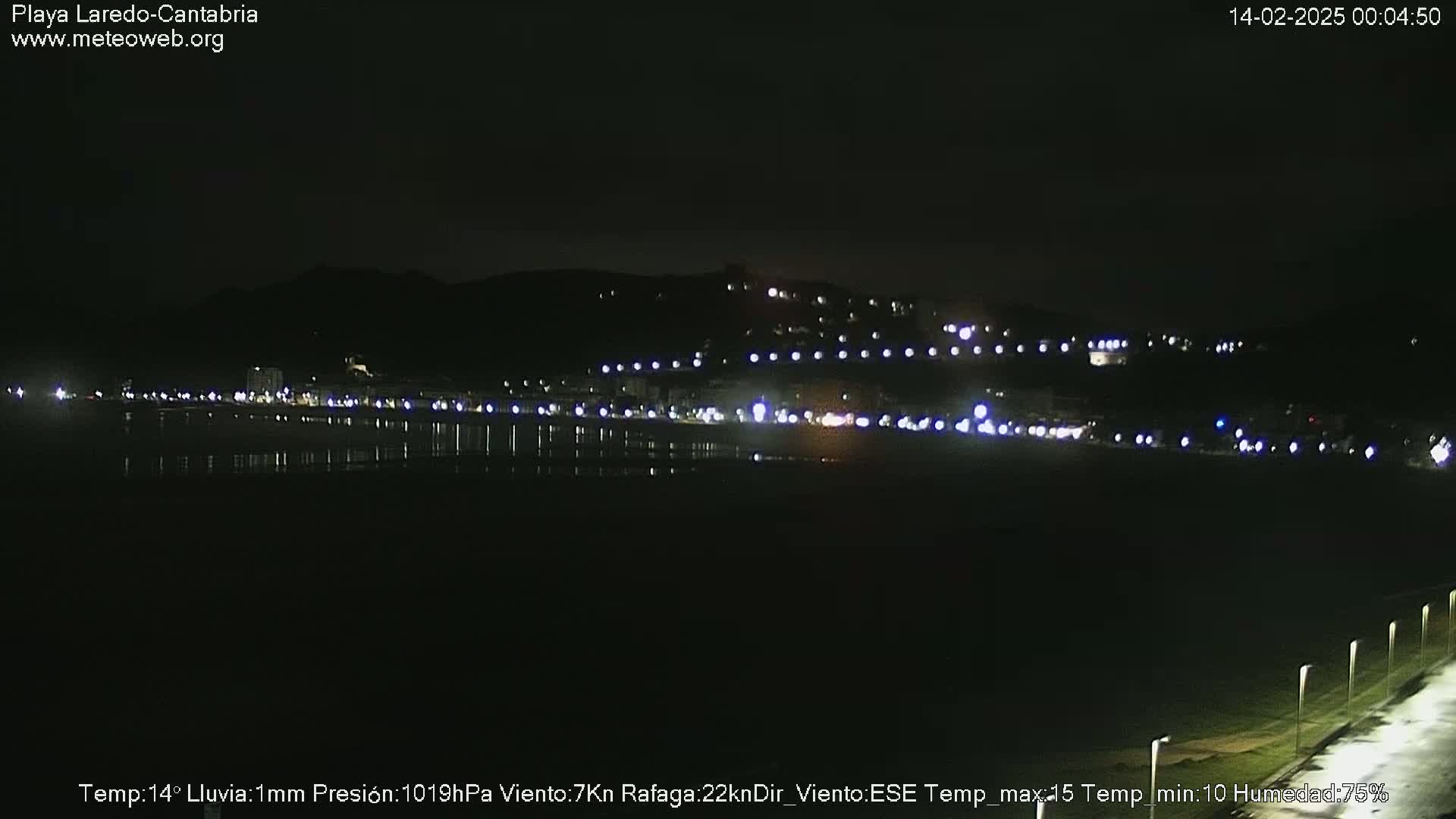 A nighttime view of a dimly lit beach town on a dark, rainy night.