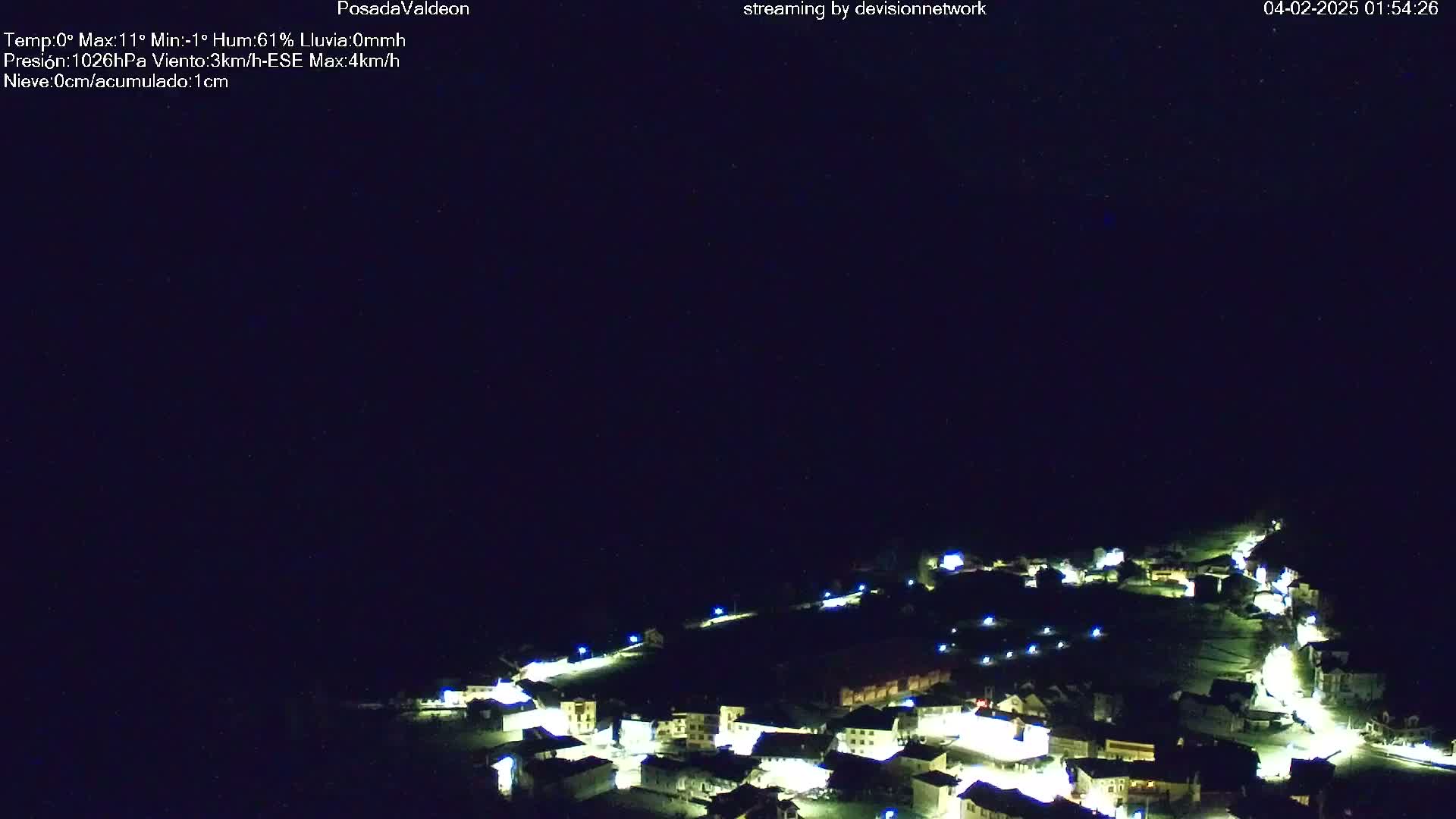 A small village illuminated at night under a dark, clear sky.