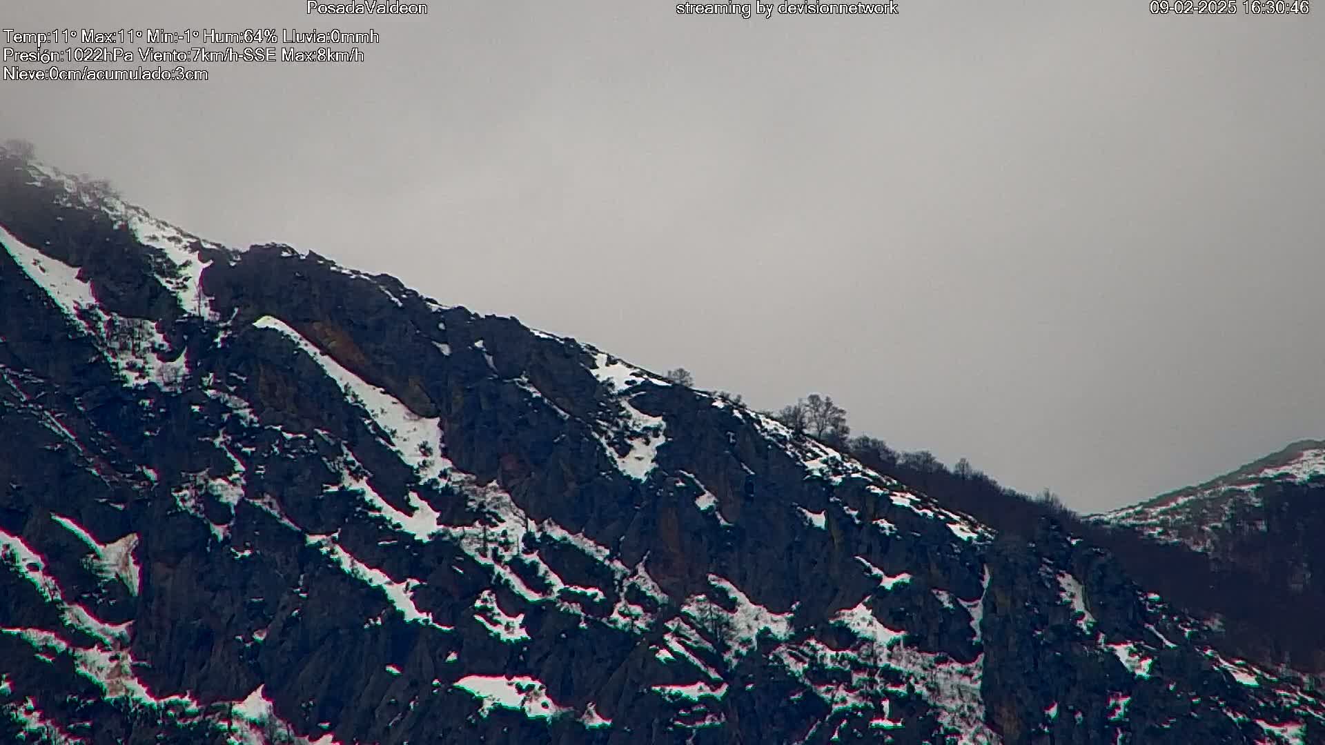 A snow-dusted mountainside under an overcast sky.