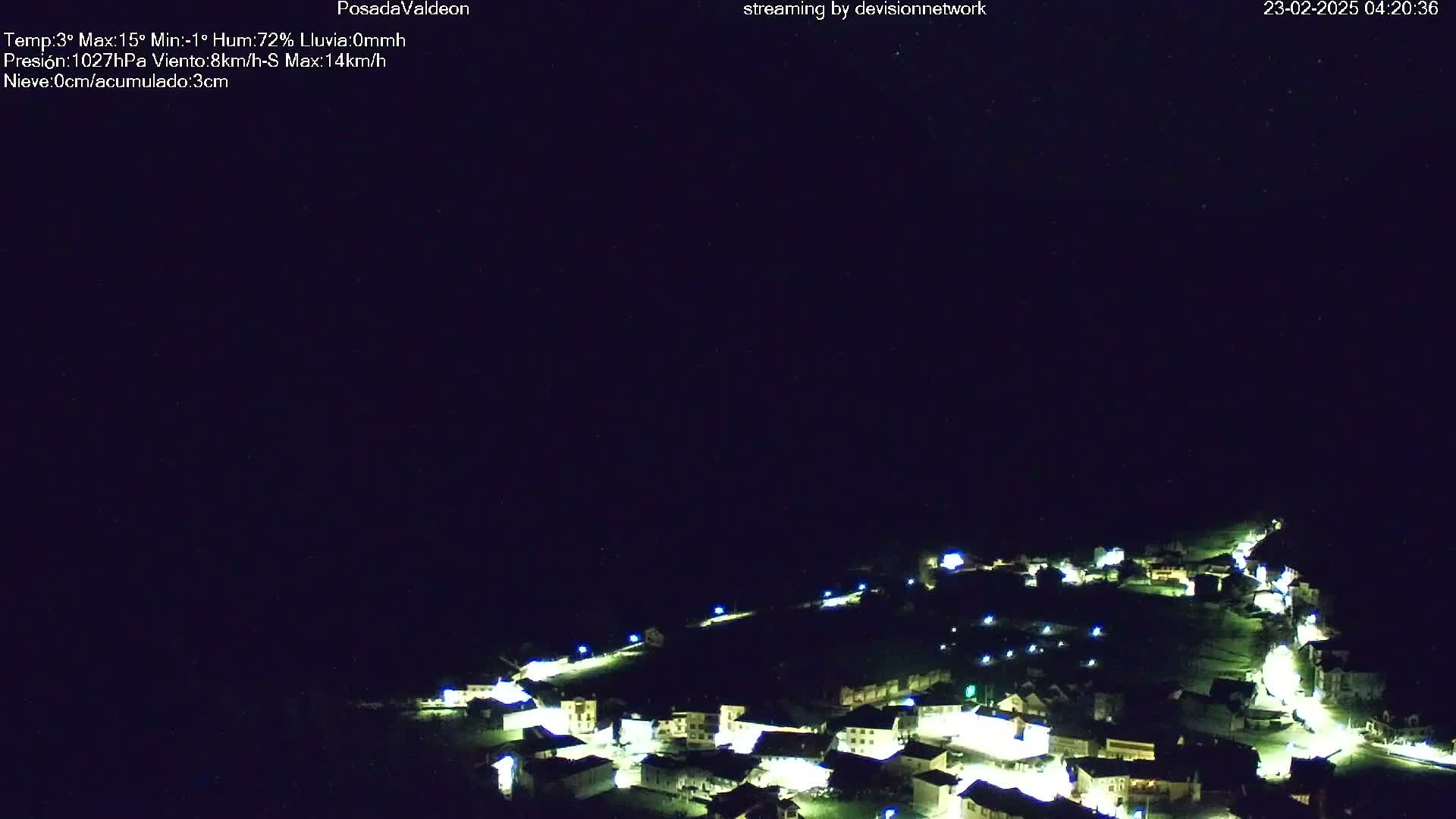 A small village illuminated at night under a dark, clear sky.