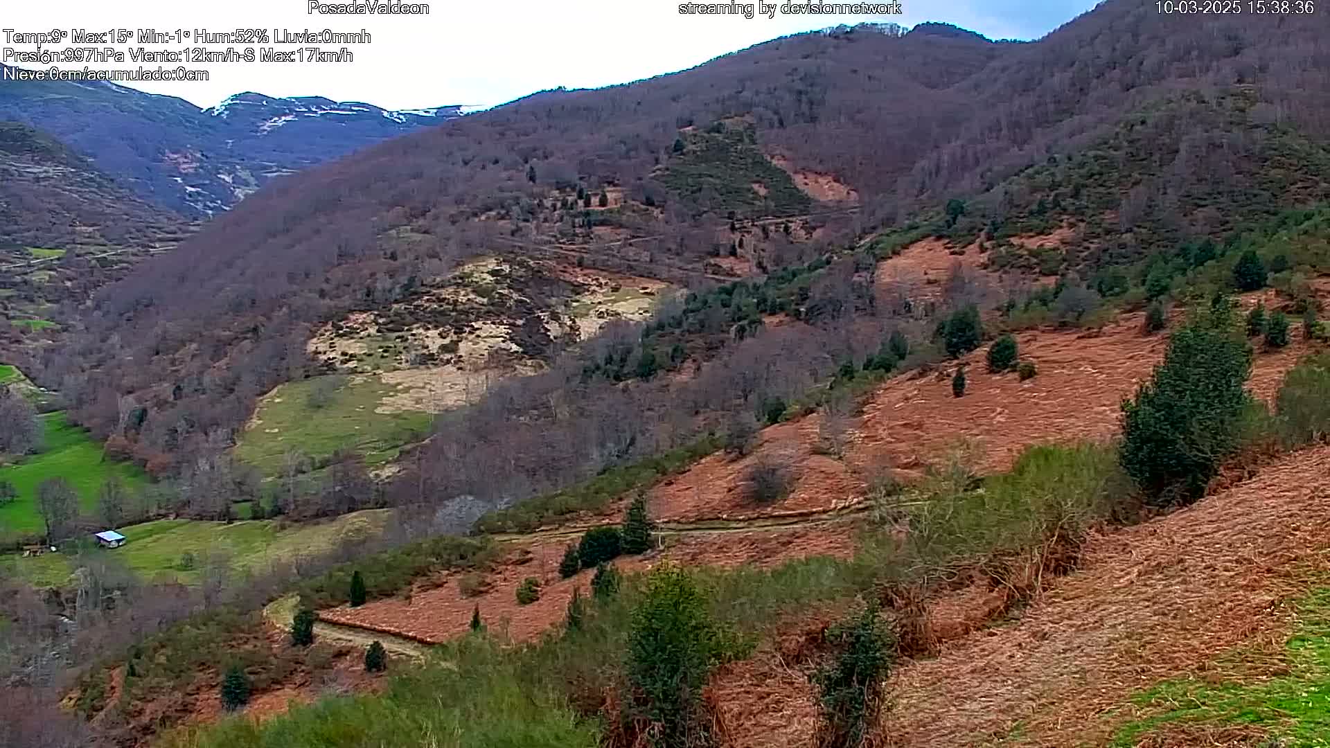 A high-angle view of a mountainous landscape with patches of brown and green vegetation under an overcast sky.