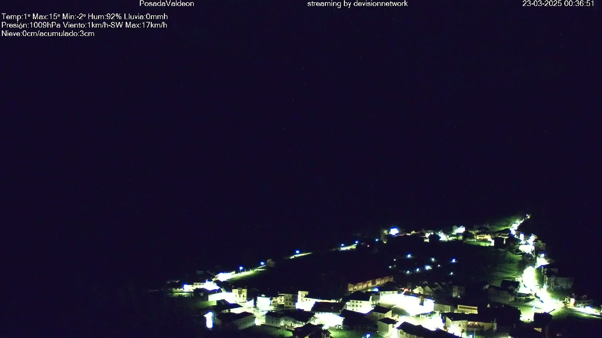 A small village is illuminated at night under a clear, dark sky.
