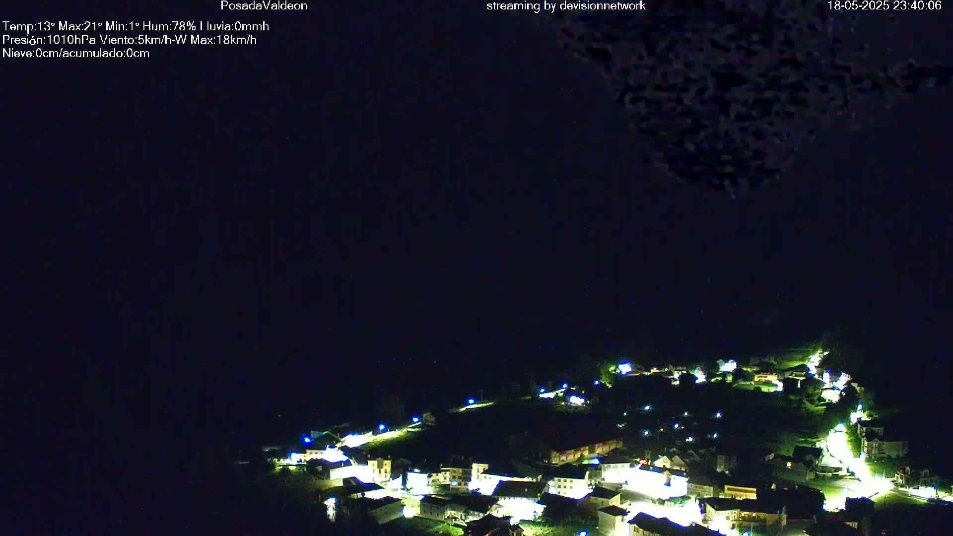 A small village illuminated at night under a dark, clear sky.