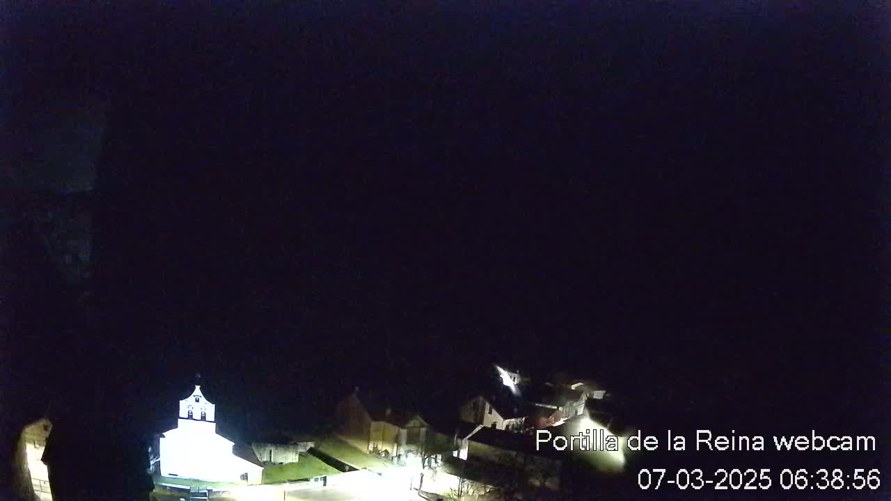 A dimly lit nighttime view of a small town, possibly under a clear sky.