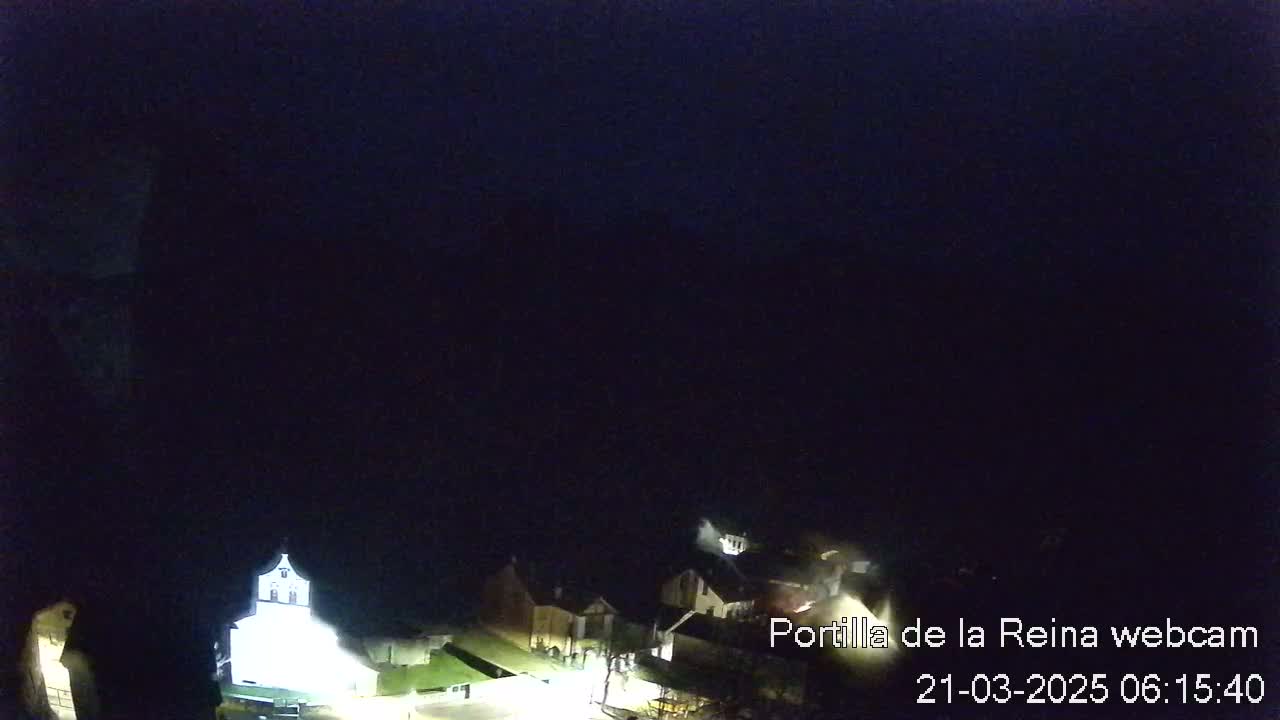 A nighttime, dimly lit view of a small town or village under a dark sky.