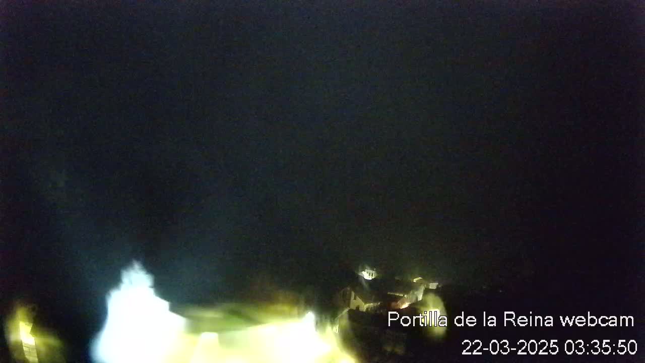 A blurry, nighttime image shows a dimly lit structure under a dark sky.